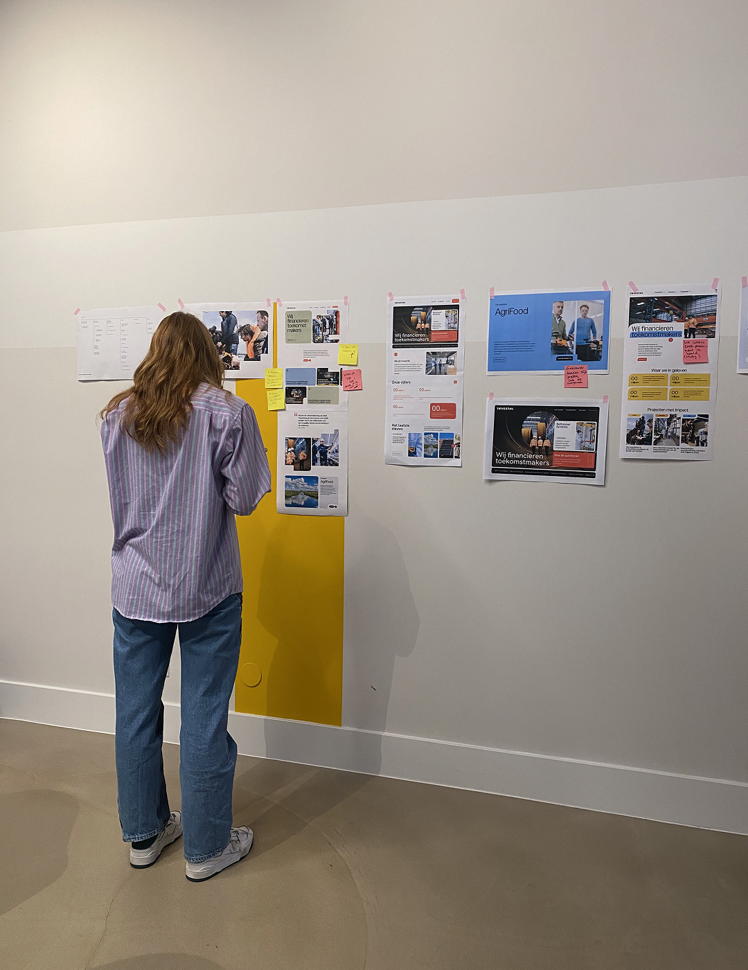 Persoon is bezig met een sessie en plakt post-its op de muur.