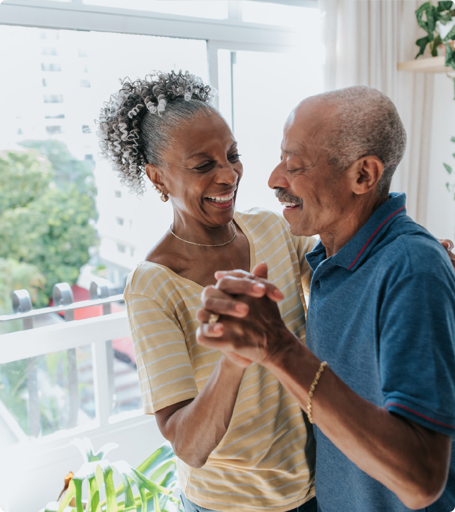 Older couple dancing in their home.