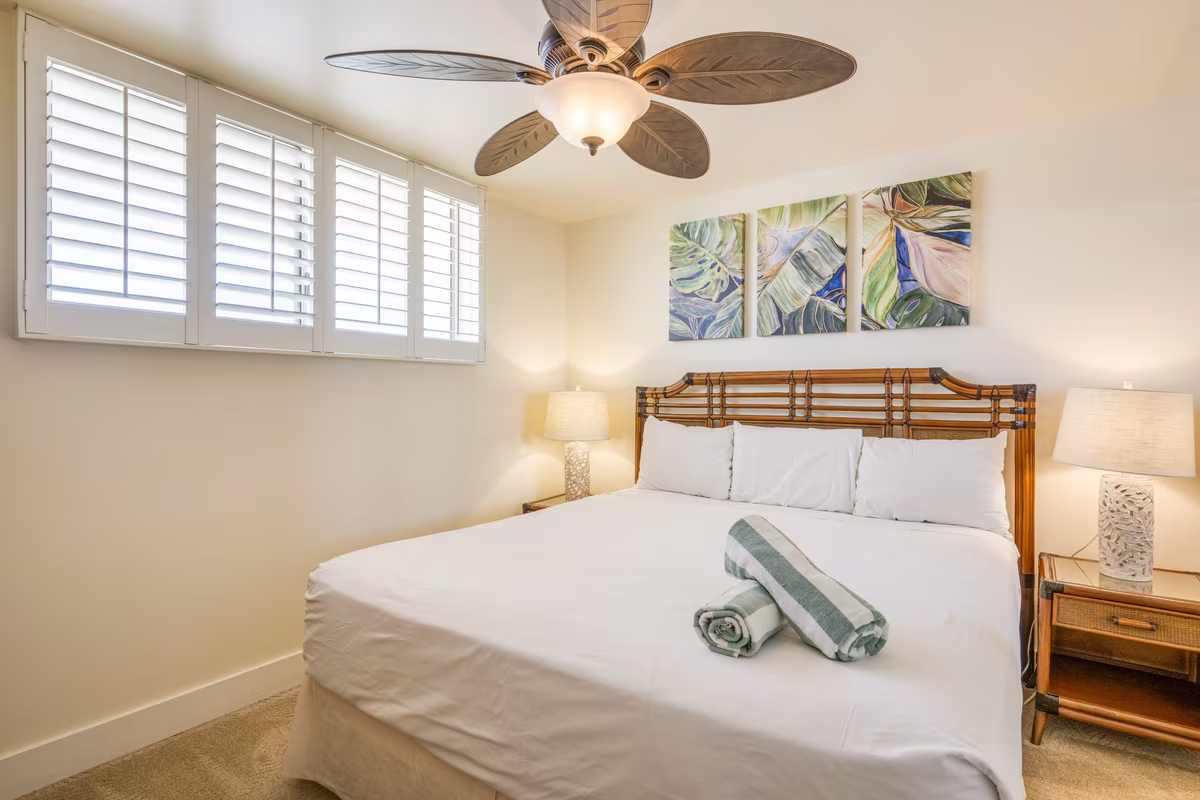 A bedroom with plantation shutters and tropical furnishings