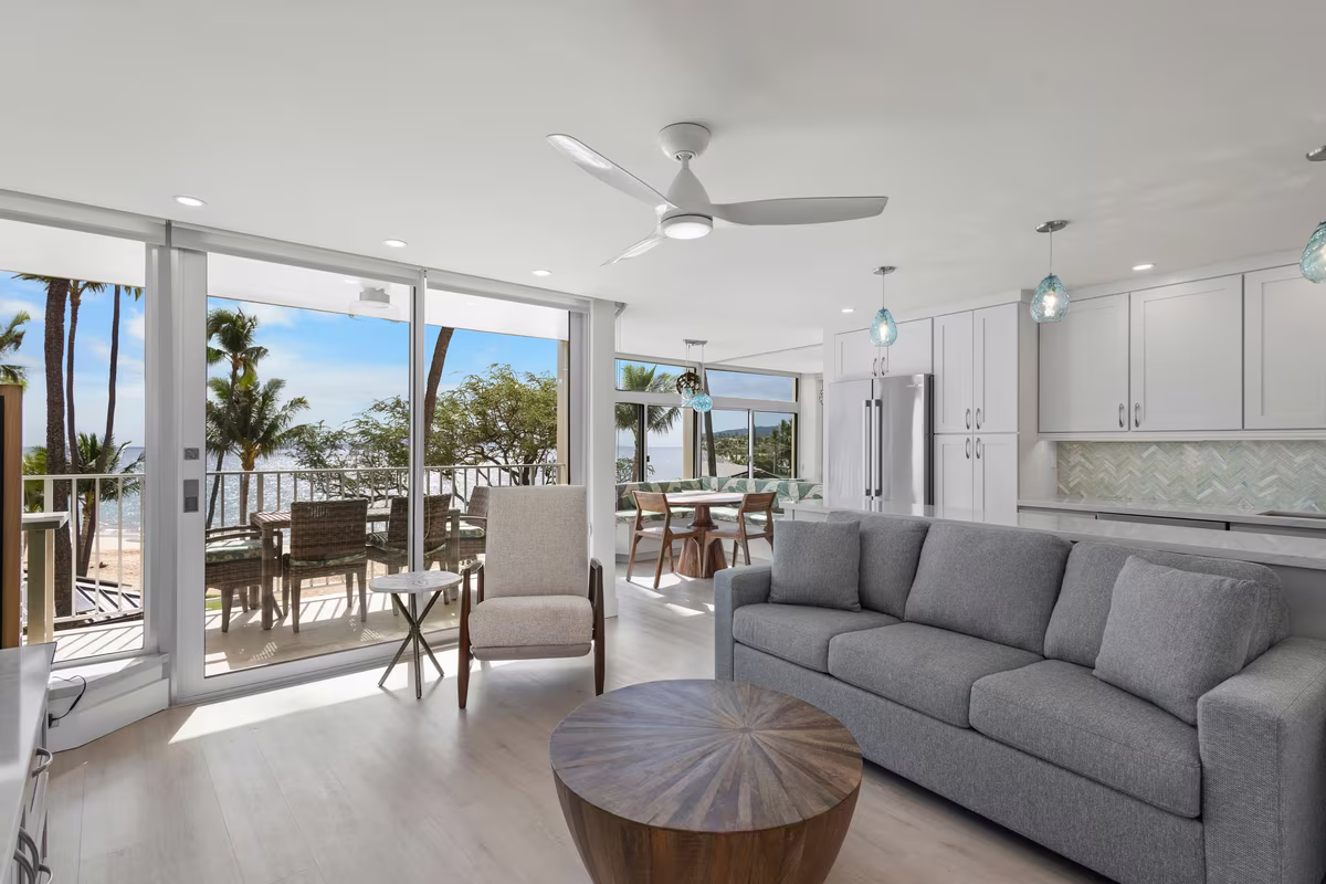 An open plan living room with sliding doors onto an oceanfront lanai