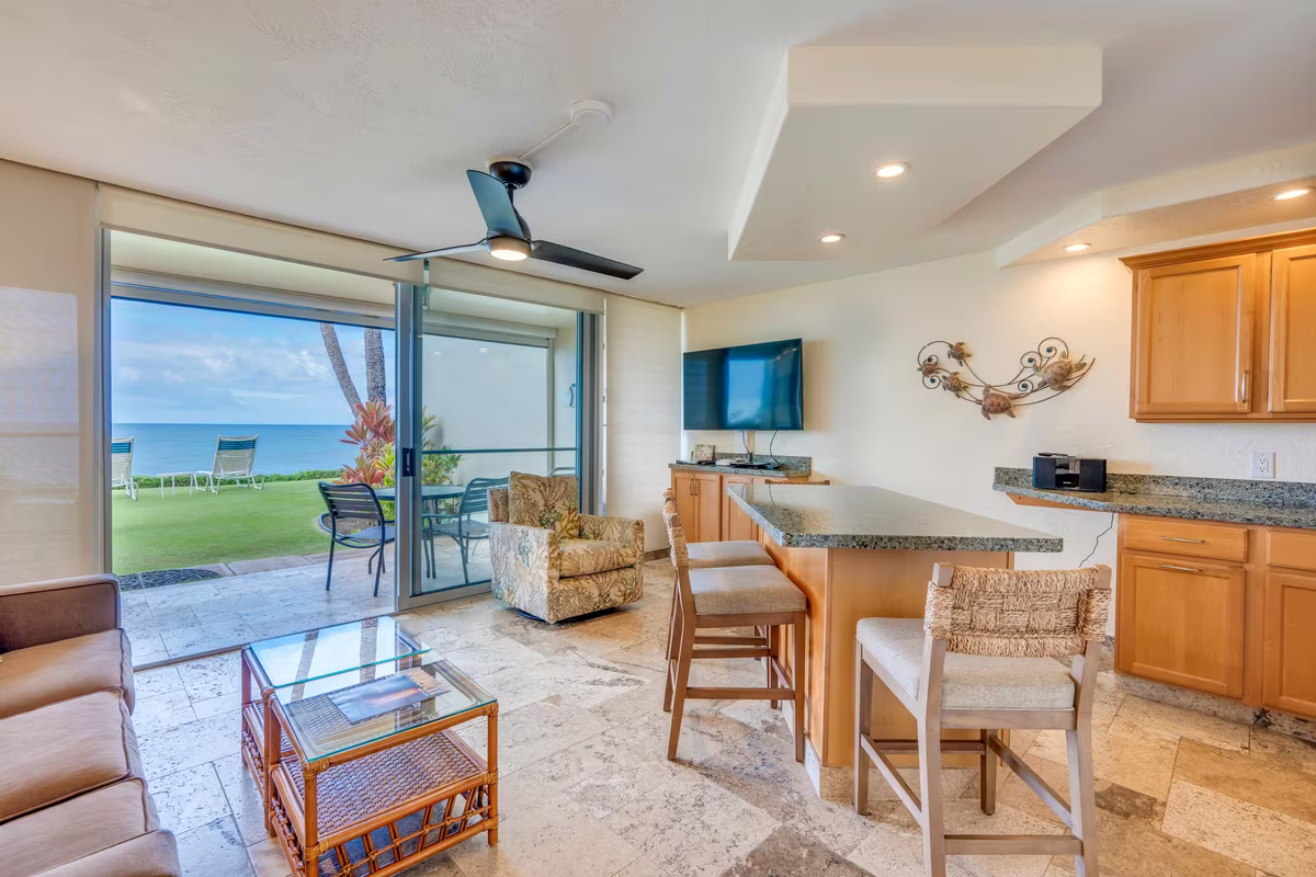 A living room opening onto the lanai with the ocean beyond