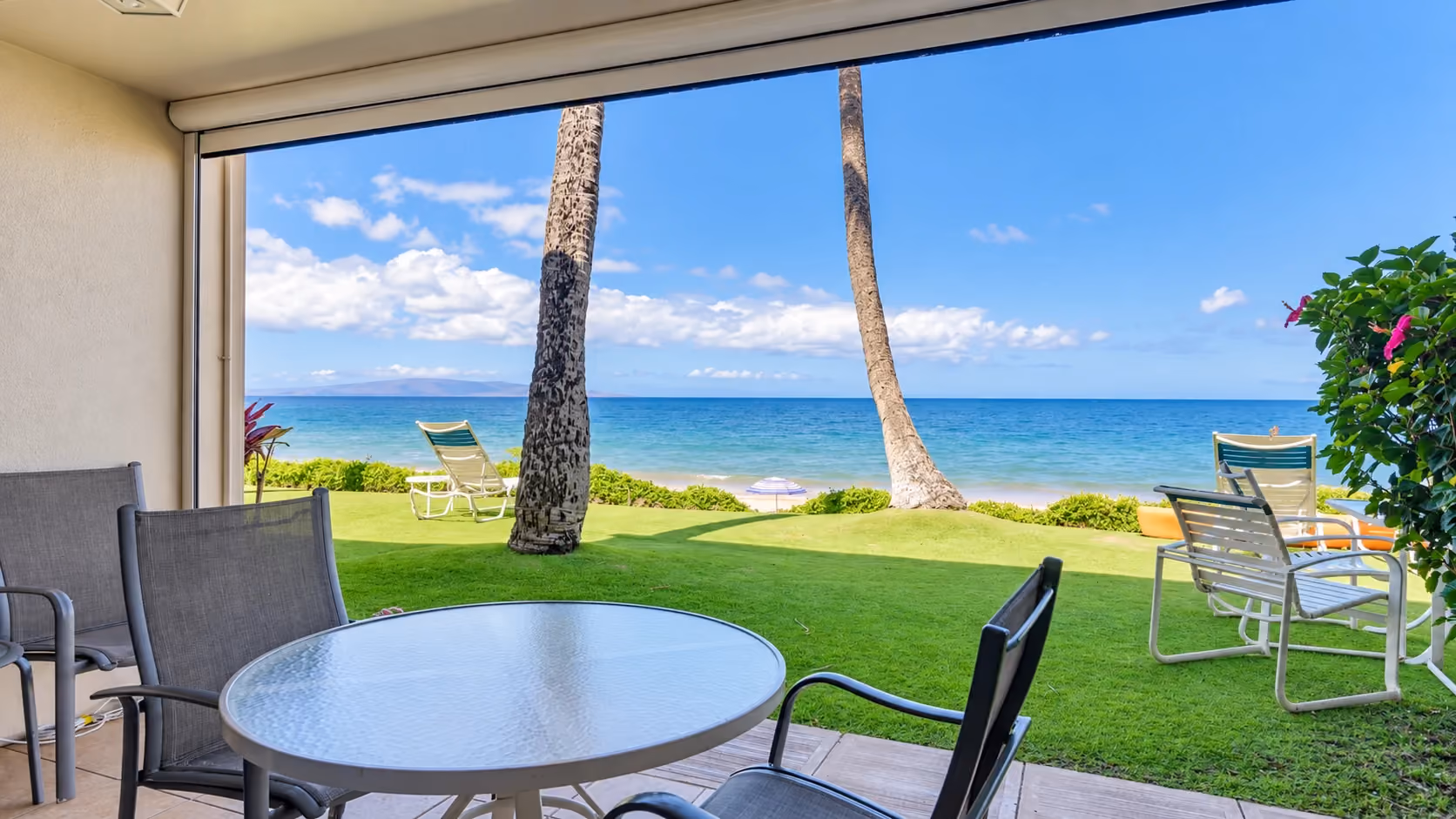 Ground-floor Unit 10 lanai opening toward the lawn and ocean at Hale Pau Hana.