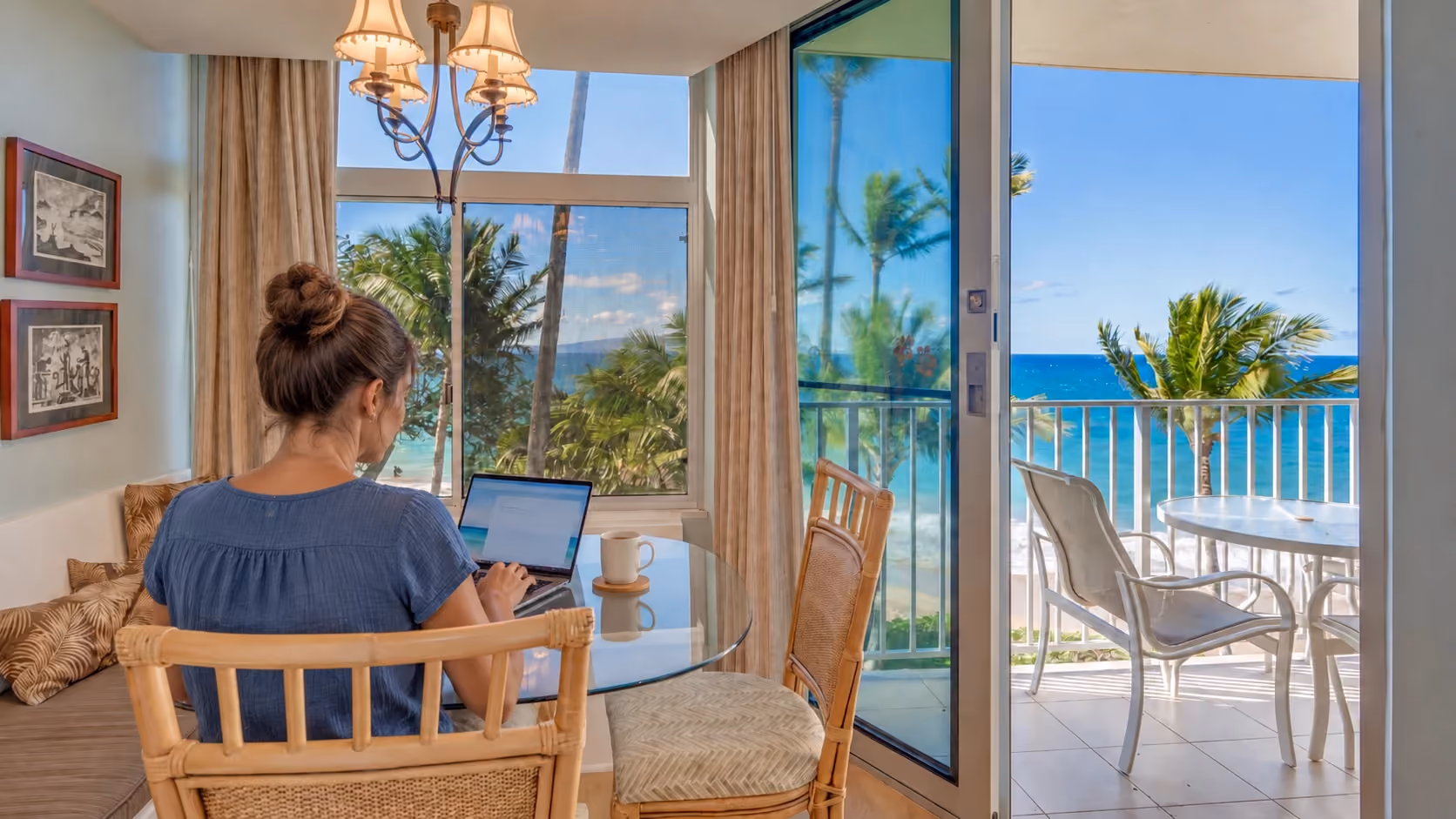 A guest working on a laptop in Unit 404’s ocean-view dining nook.