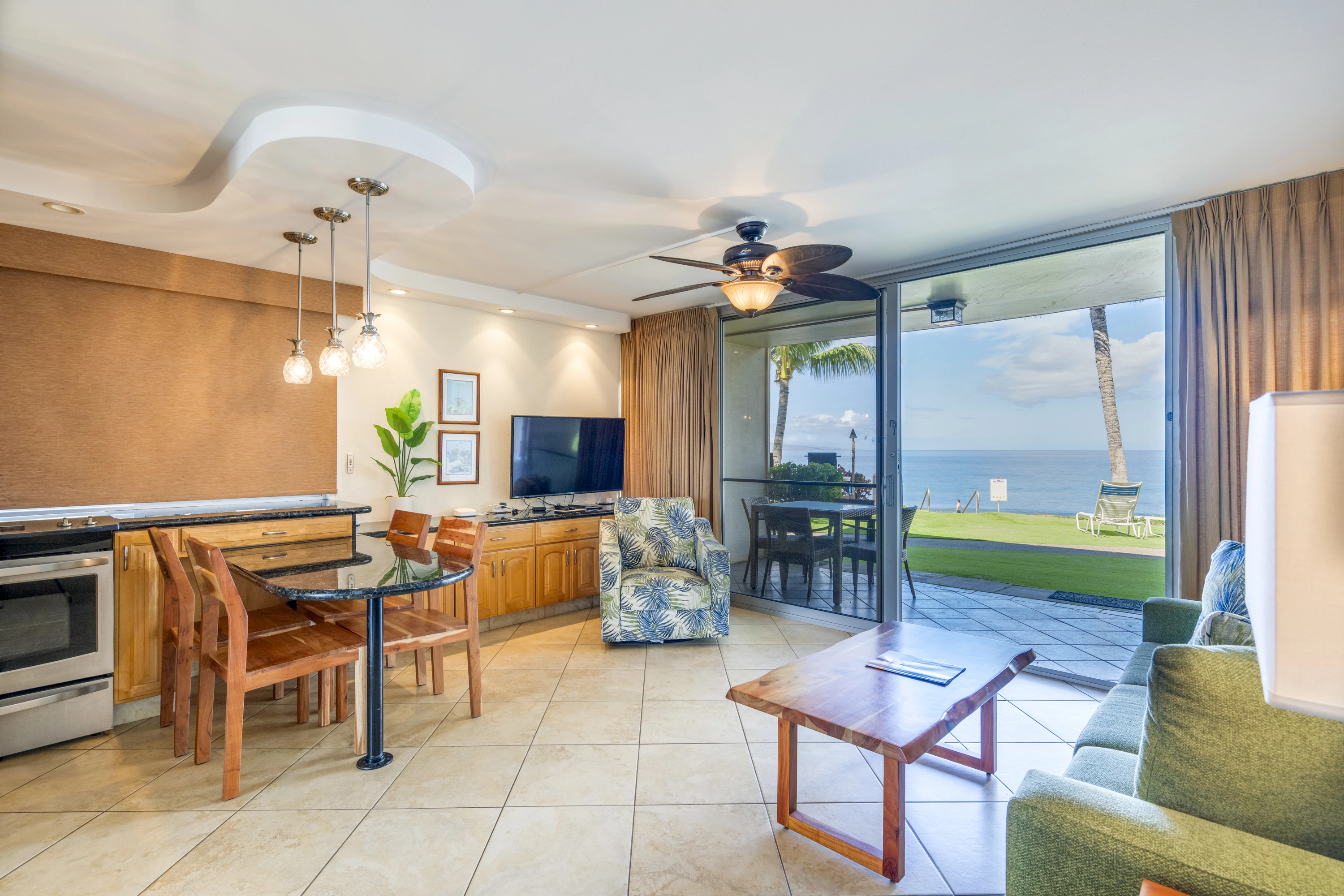 Living and dining area opening onto the oceanfront lawn.