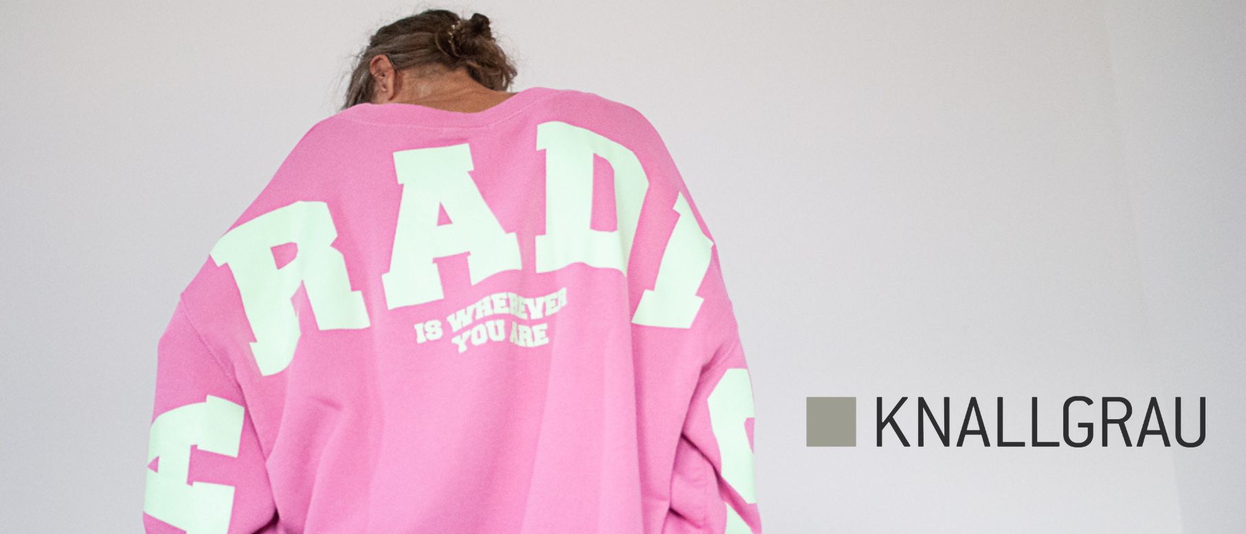 Frau ein einem pinken großen Pulli von Liv Bergen mit weißen Buchstaben