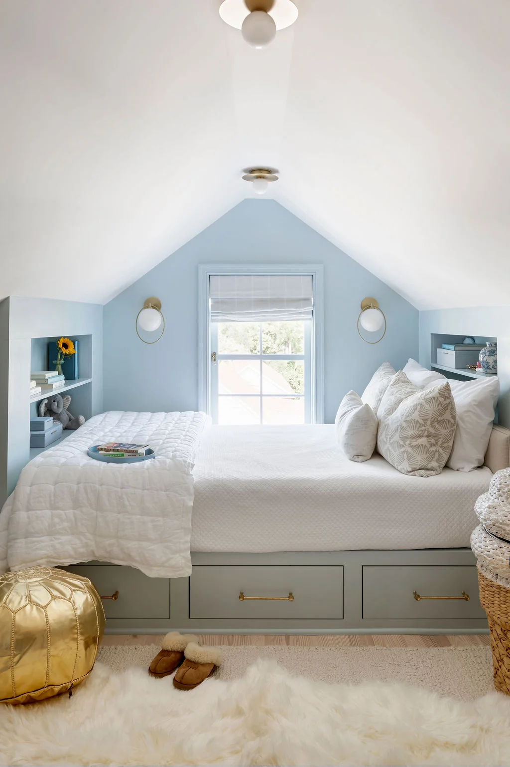 Charming built-in bunk room featuring soft blue millwork, integrated storage drawers, custom shelving, and layered bedding. Designed by PWD Studio, this cozy retreat maximizes functionality while embracing timeless coastal style.