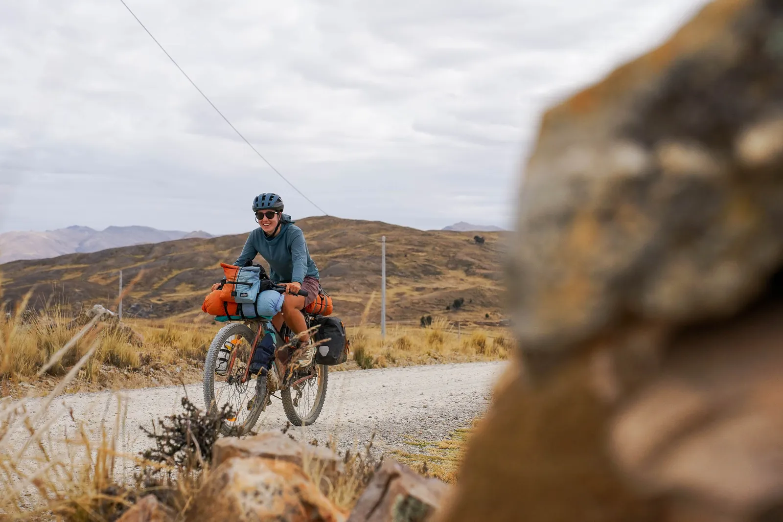 Kona bike loaded for a gravel road adventure, cyclist in a barren mountain landscape