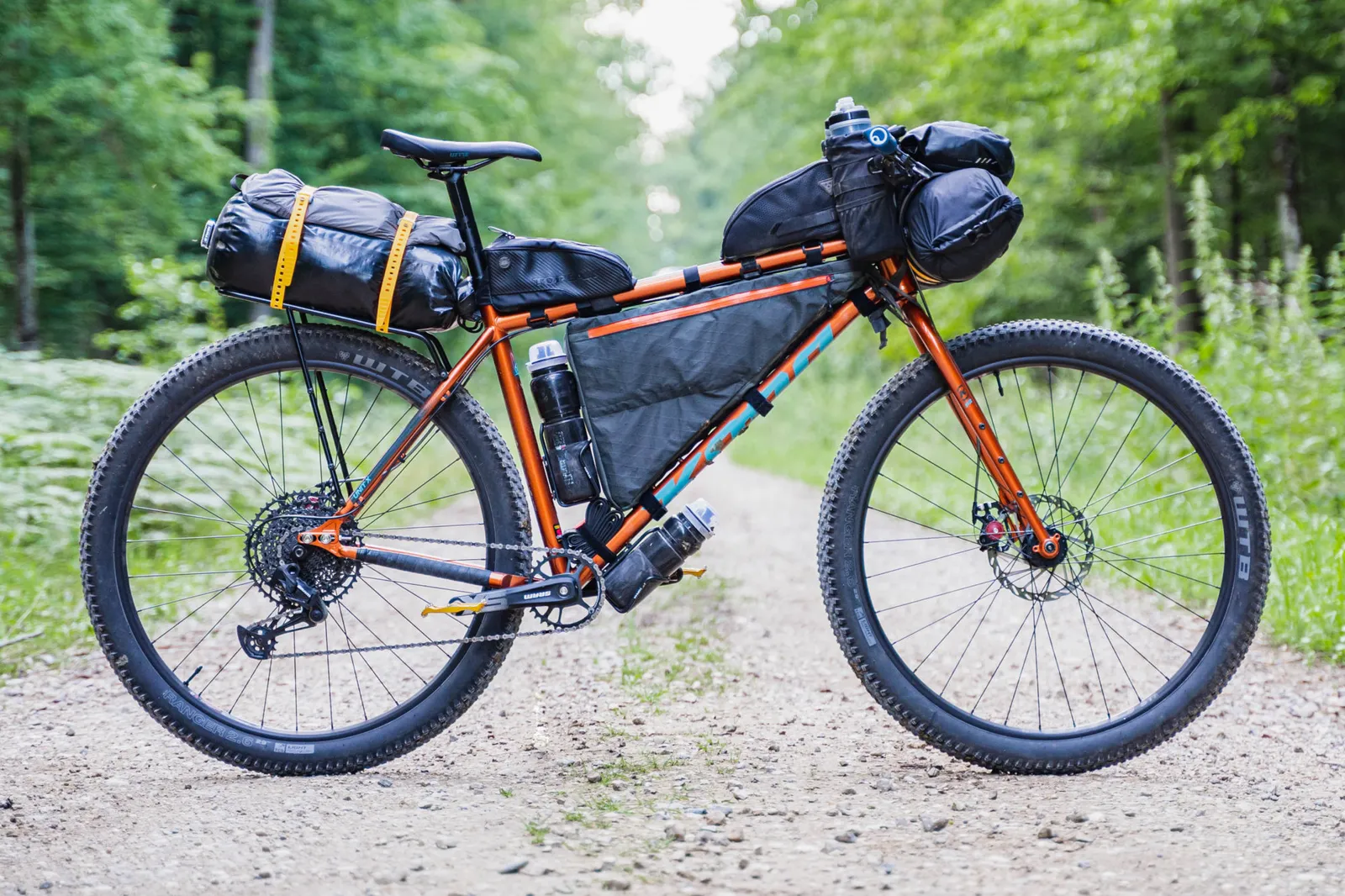 Orange Kona bike ready for an adventure on a forest trail