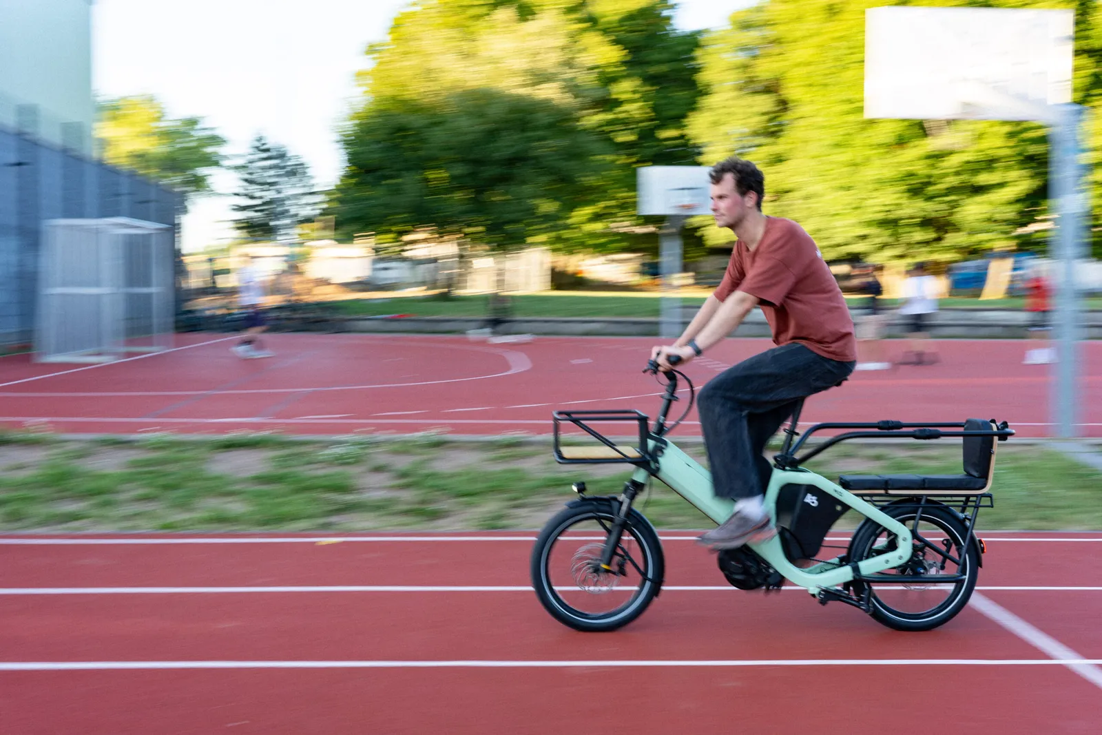 Green Bike 43 cargo bike on a red trail with a cyclist in motion