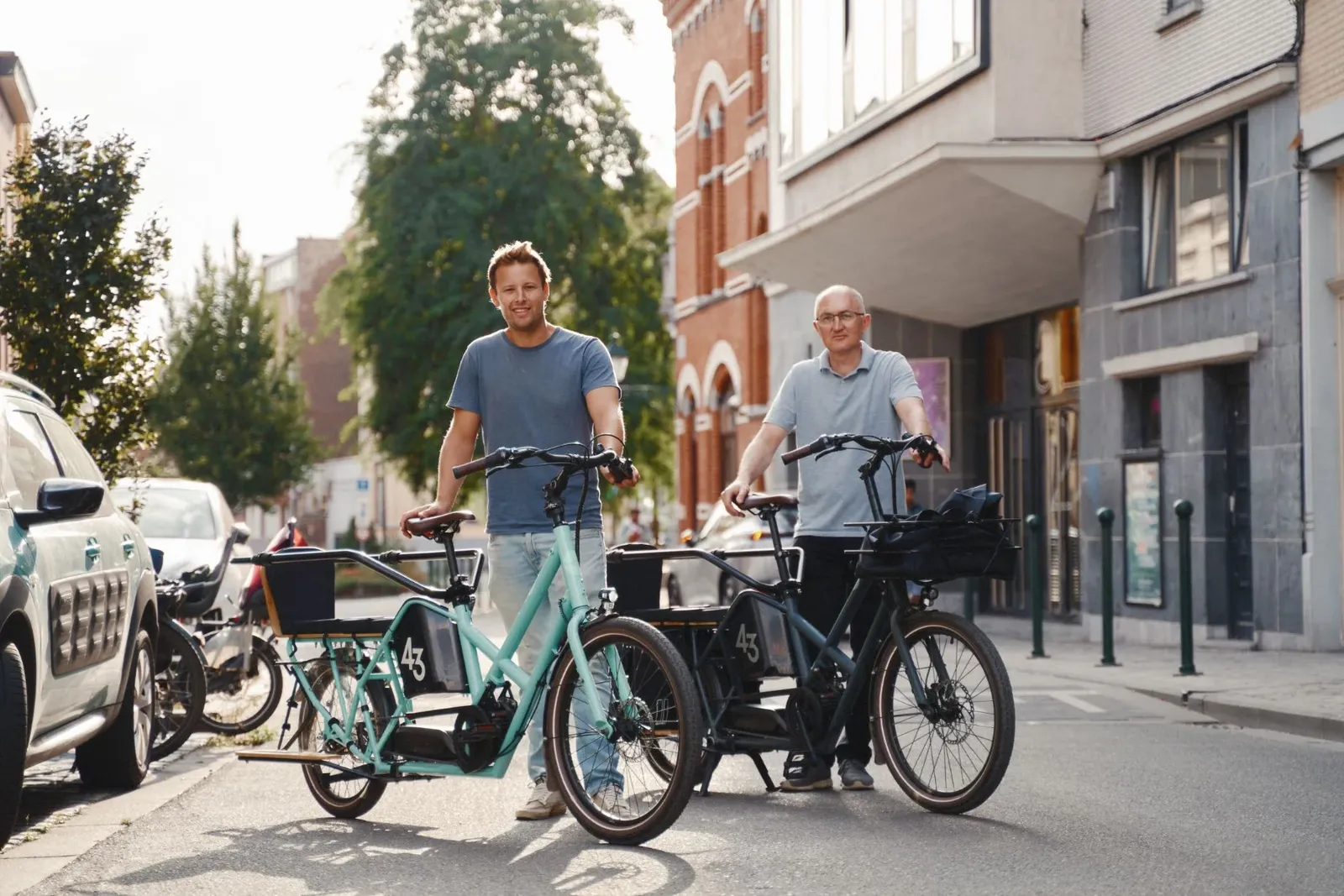 Black and turquoise Bike 43 cargo bikes in the city, two smiling people