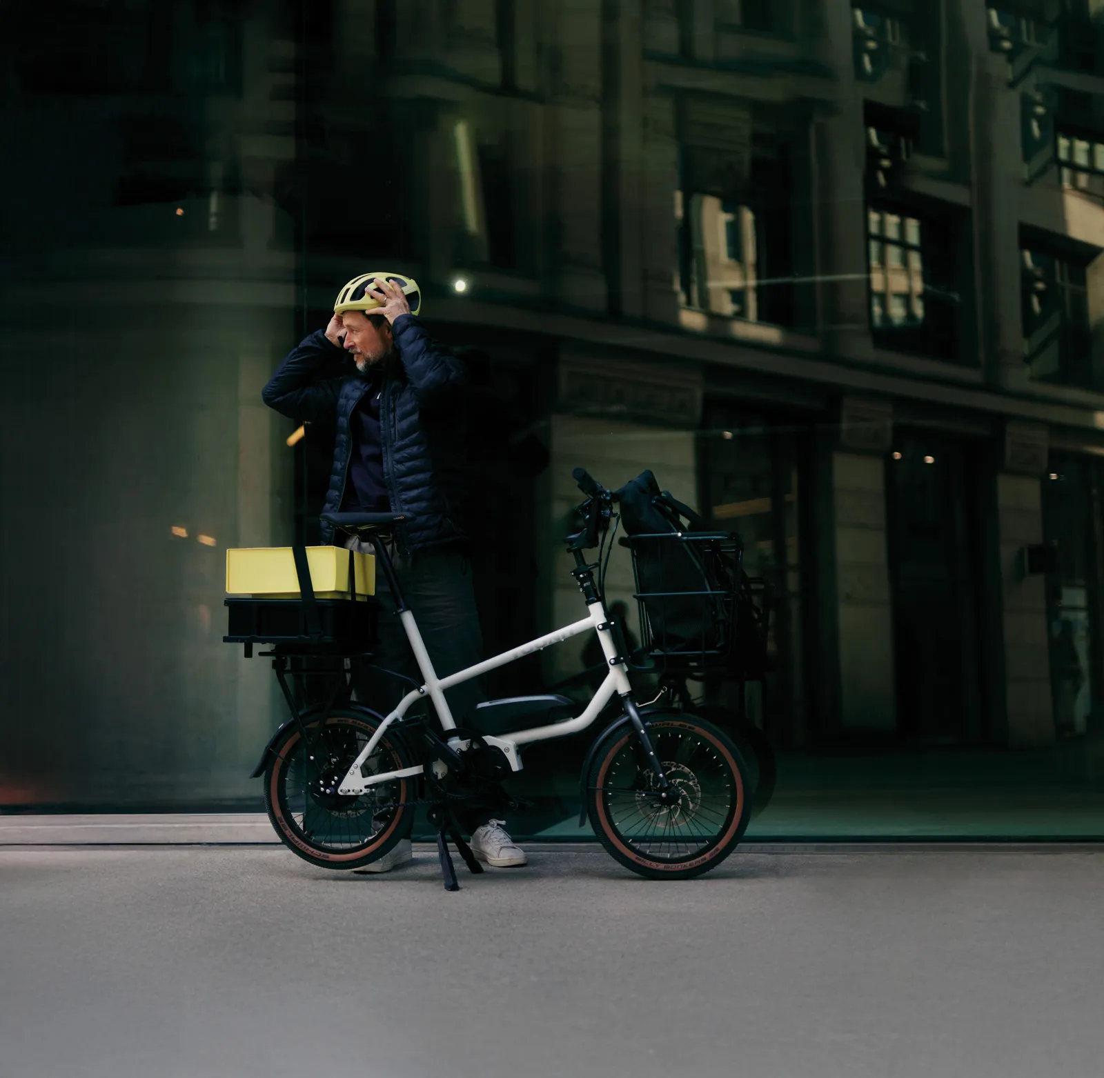 White Yoonit cargo bike with a sturdy frame in front of an urban building