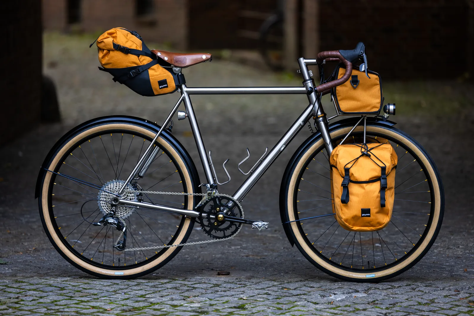Intec touring bike with a gray steel frame, yellow panniers, and a brown leather handlebar