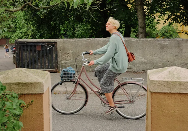 Vintage pink Pelago bike with a basket in a lush urban setting