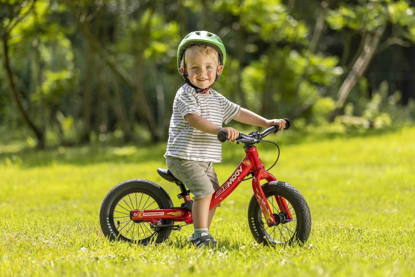 BeMoov red children's bike, lightweight frame, green lawn in the background
