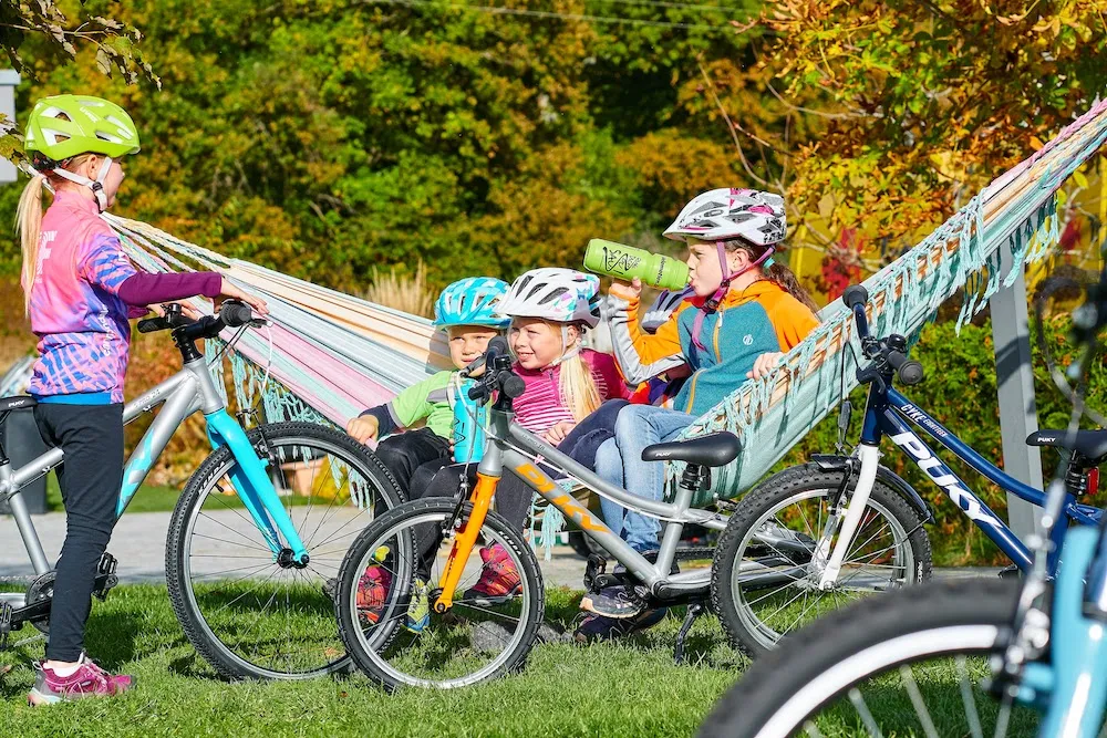 Colorful Puky children's bikes outdoors, aluminum frames, children wearing helmets, a sunny day