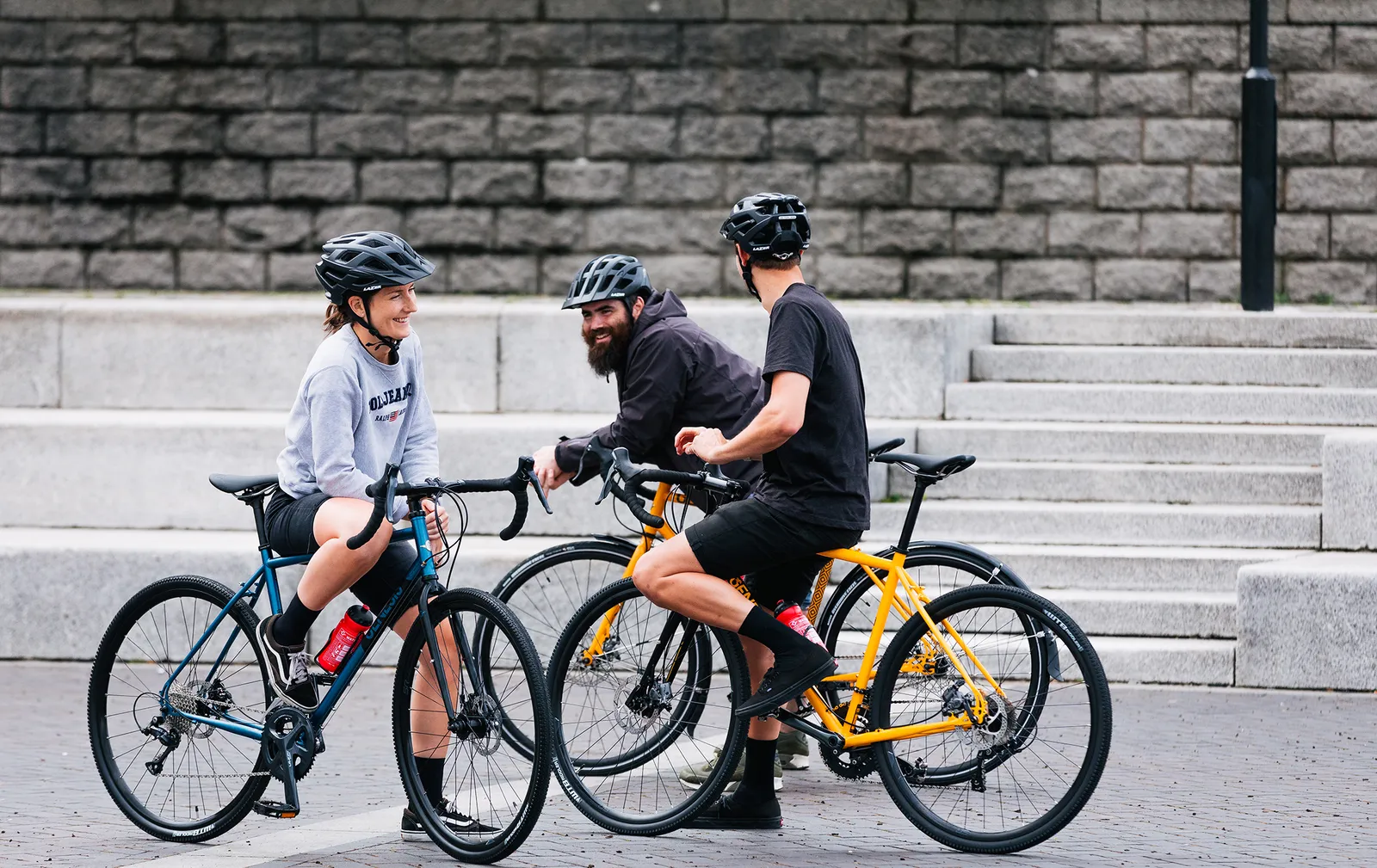 Vélos Genesis colorés en acier dans un parc urbain avec des cyclistes souriants