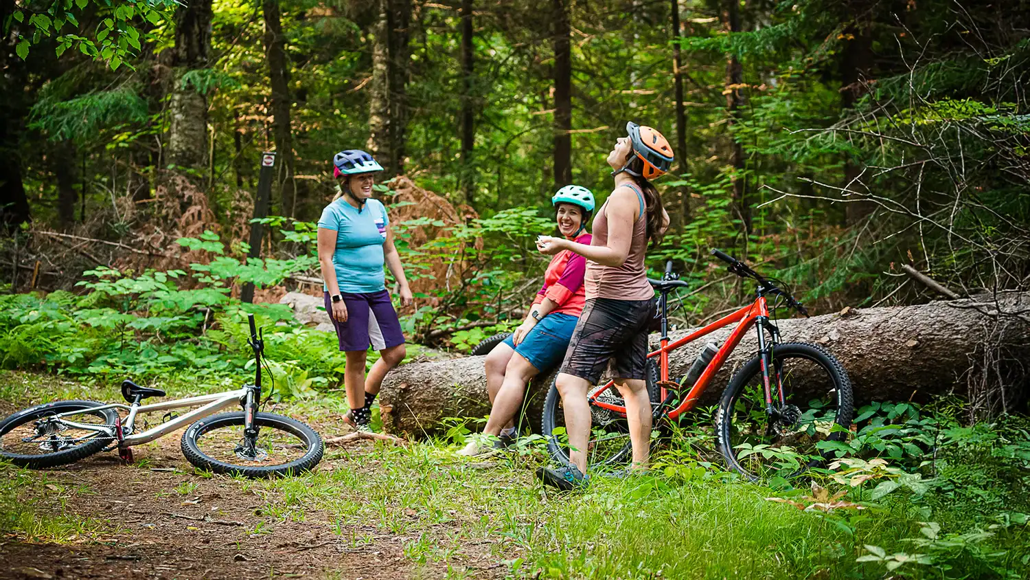 Vélo tout-terrain Salsa rouge sur sentier forestier avec cyclistes en tenue colorée