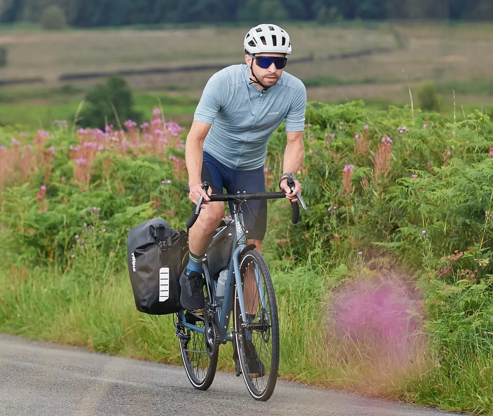 Blue Ridgeback road bike with a pannier on a lush country road