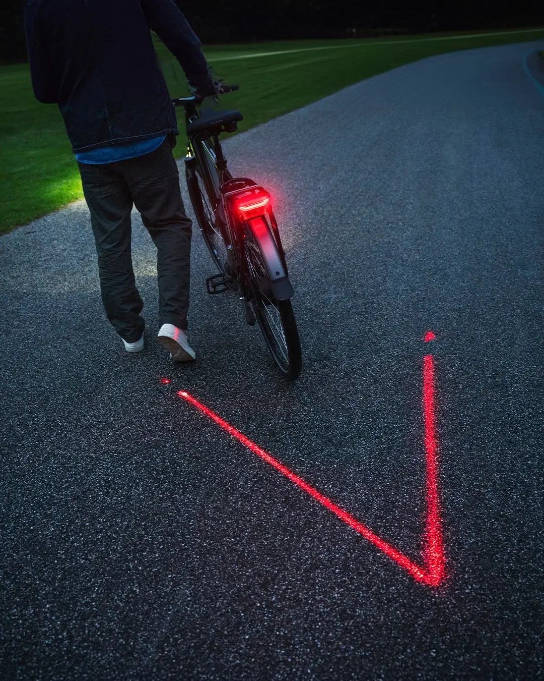 Black Batavus e-bike on a bike path, with a red taillight on