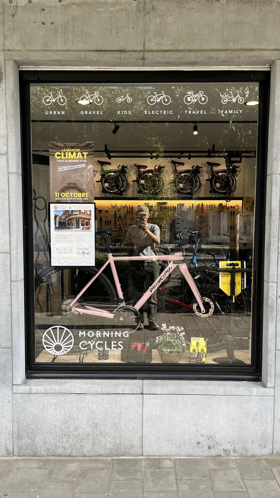 Vitrine de Morning Cycles avec un vélo rose et divers accessoires de cyclisme exposés.