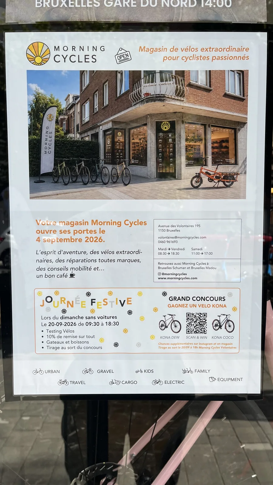 Affiche du magasin de vélos Morning Cycles avec détails sur l'ouverture et un concours, devant une vitrine avec vélos.