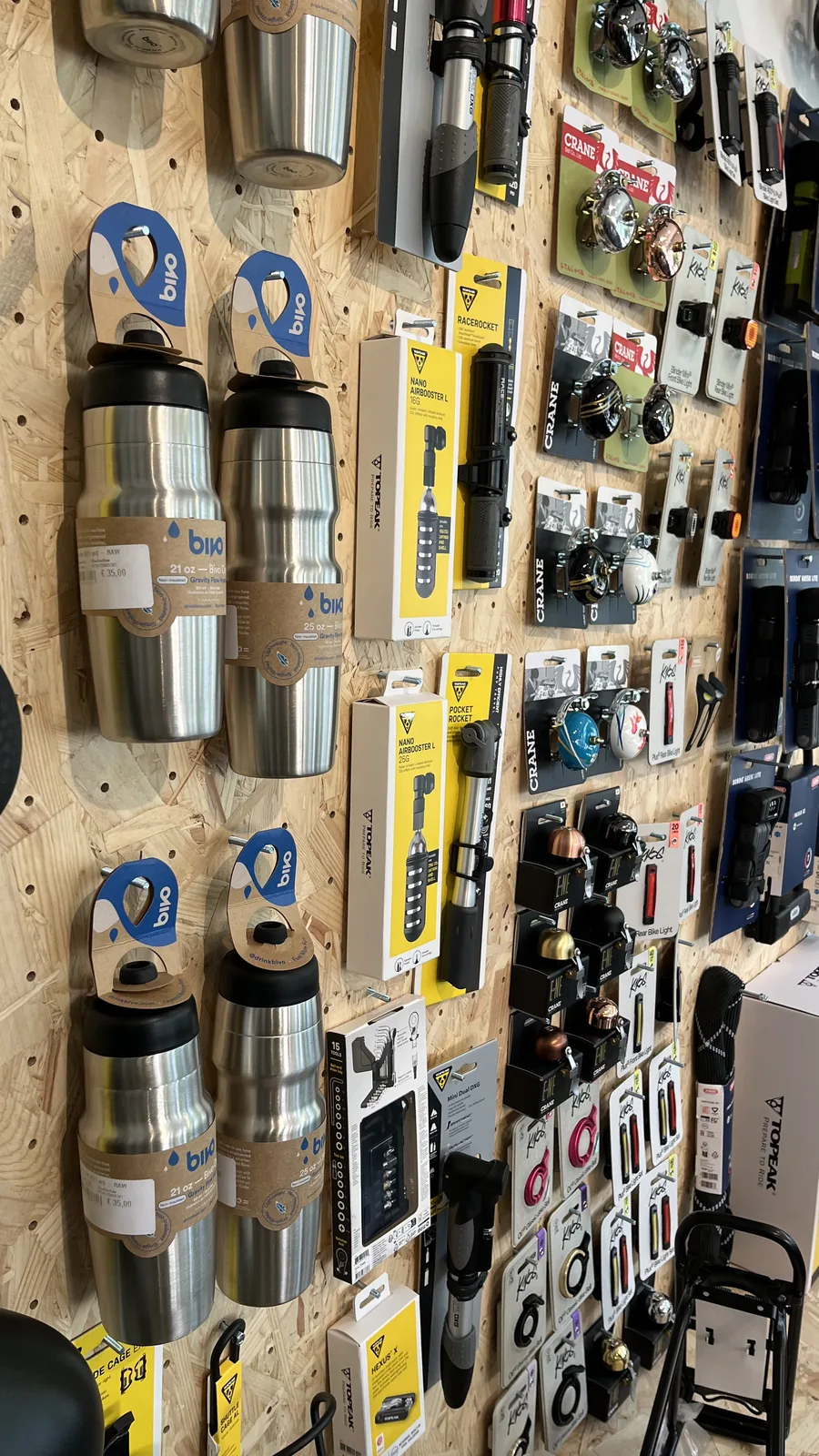 Étagère de produits d'accessoires pour vélos, incluant gourdes et divers équipements de marque.