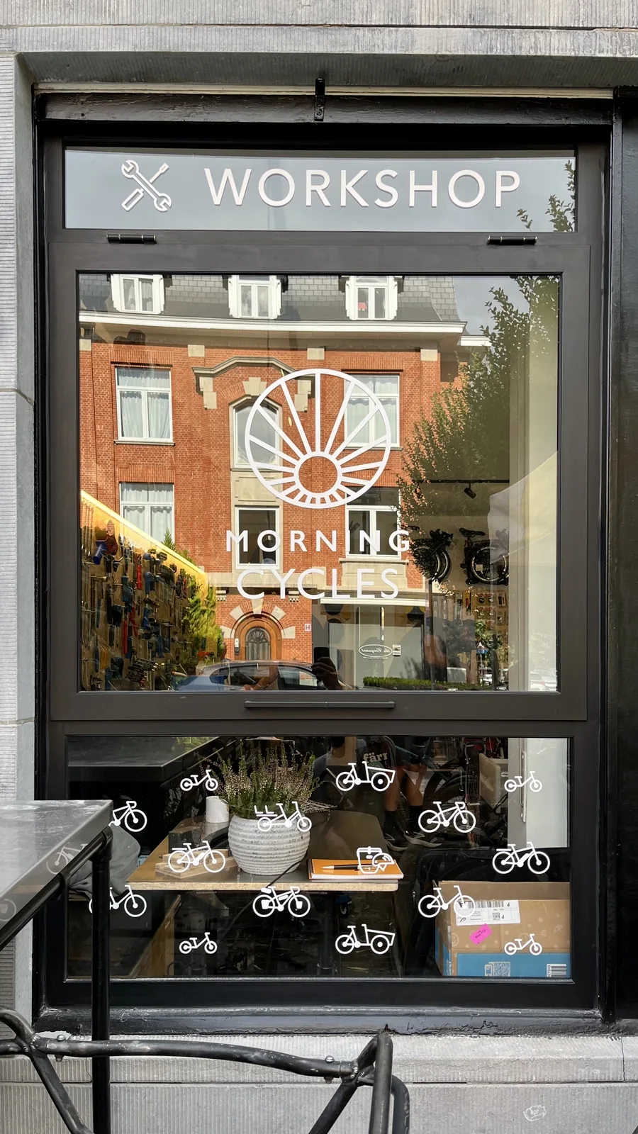 Vitrine du magasin Morning Cycles avec logo et décorations illustrant des vélos.