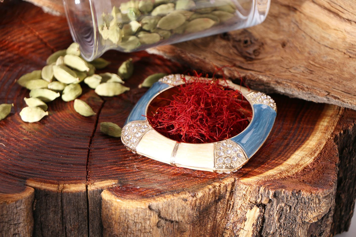 A dish of picked saffron threads in a ceramic dish, placed on top of a wooden stump.