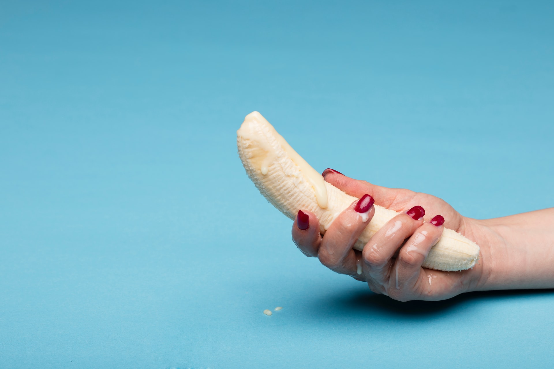 A hand holding a peeled banana