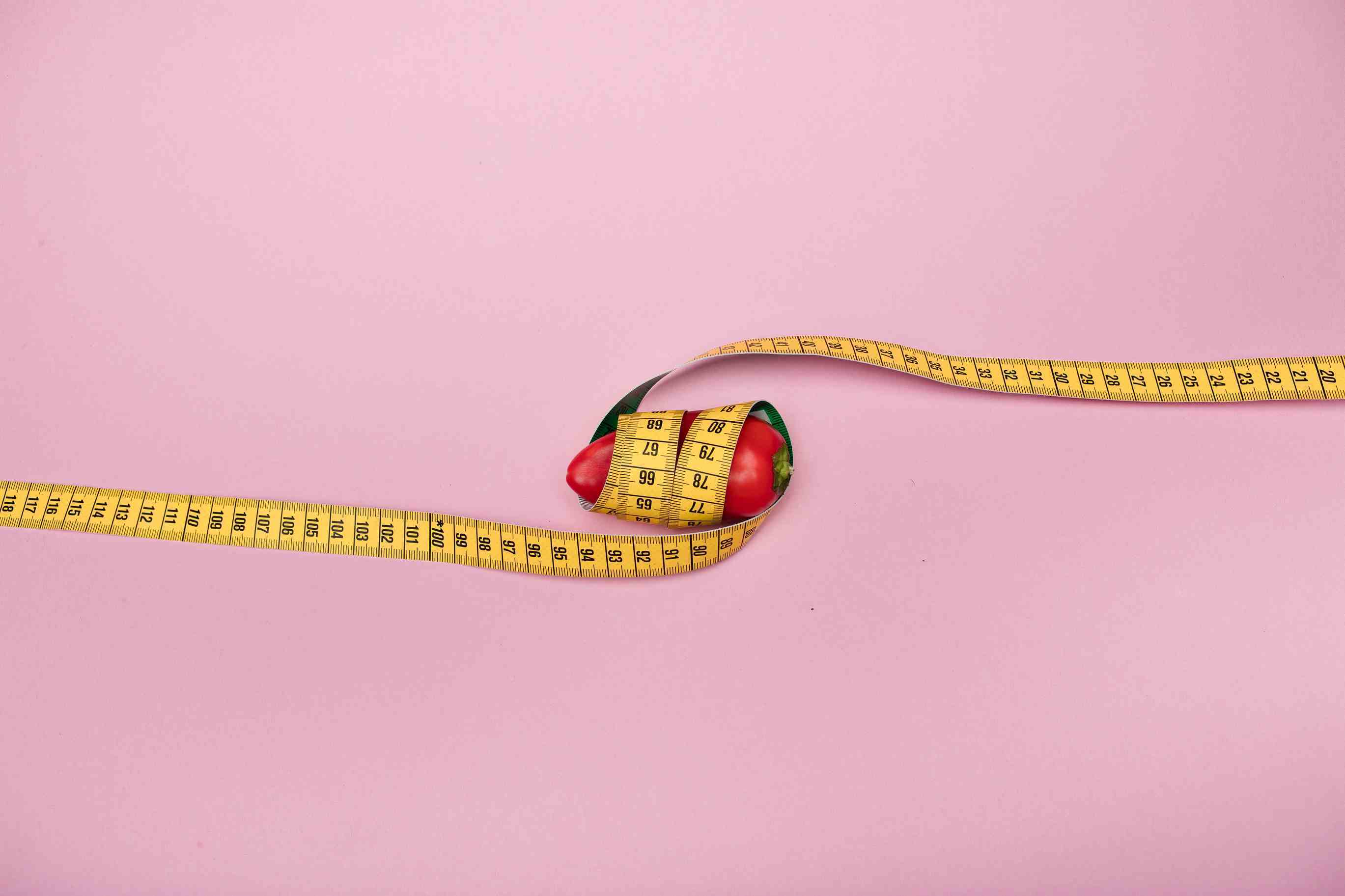 A small chili pepper wrapped in a measuring tape. 