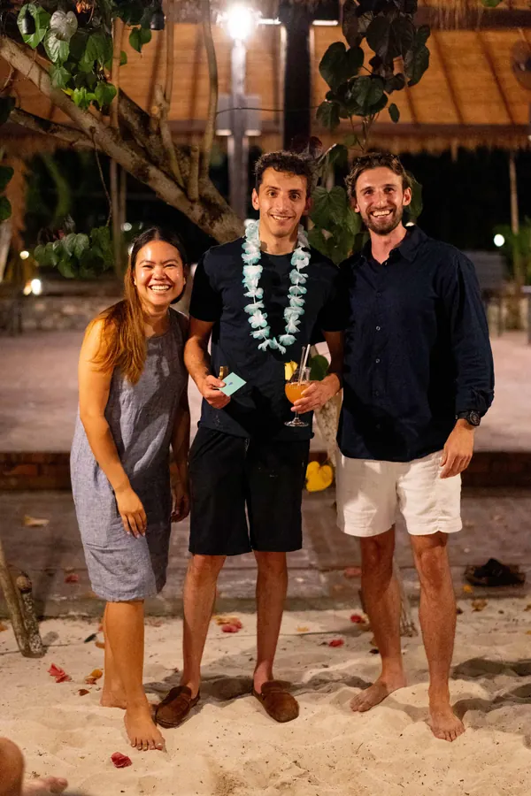 Three Gridcoggers smiling on the sand at the retreat awards night