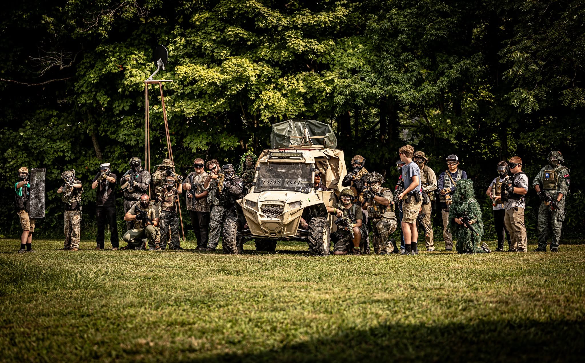 Coyote Force airsoft players gathered around a UTV at the Ladoga field