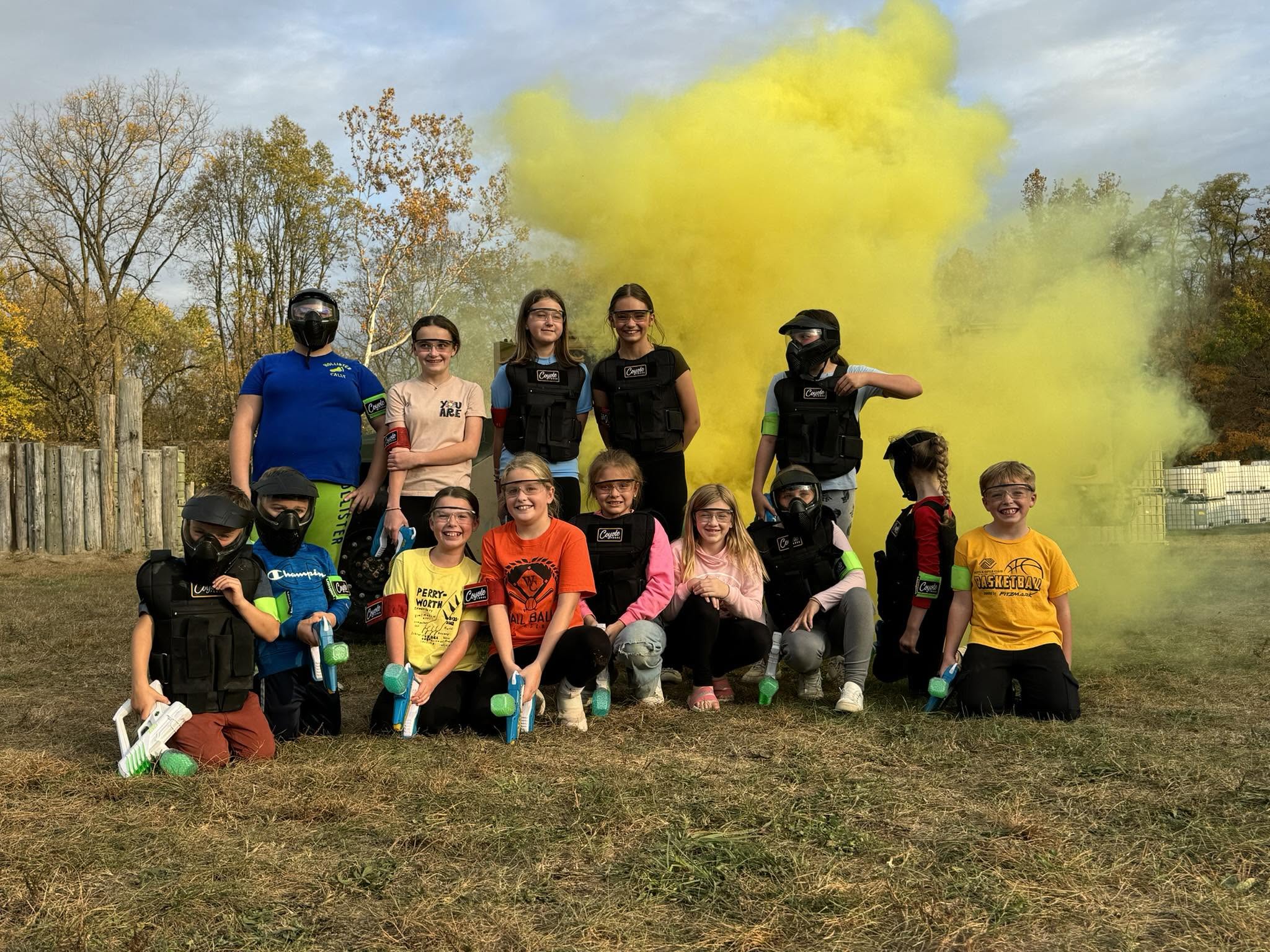 Kids playing gellyball at Coyote Force with yellow smoke in the background