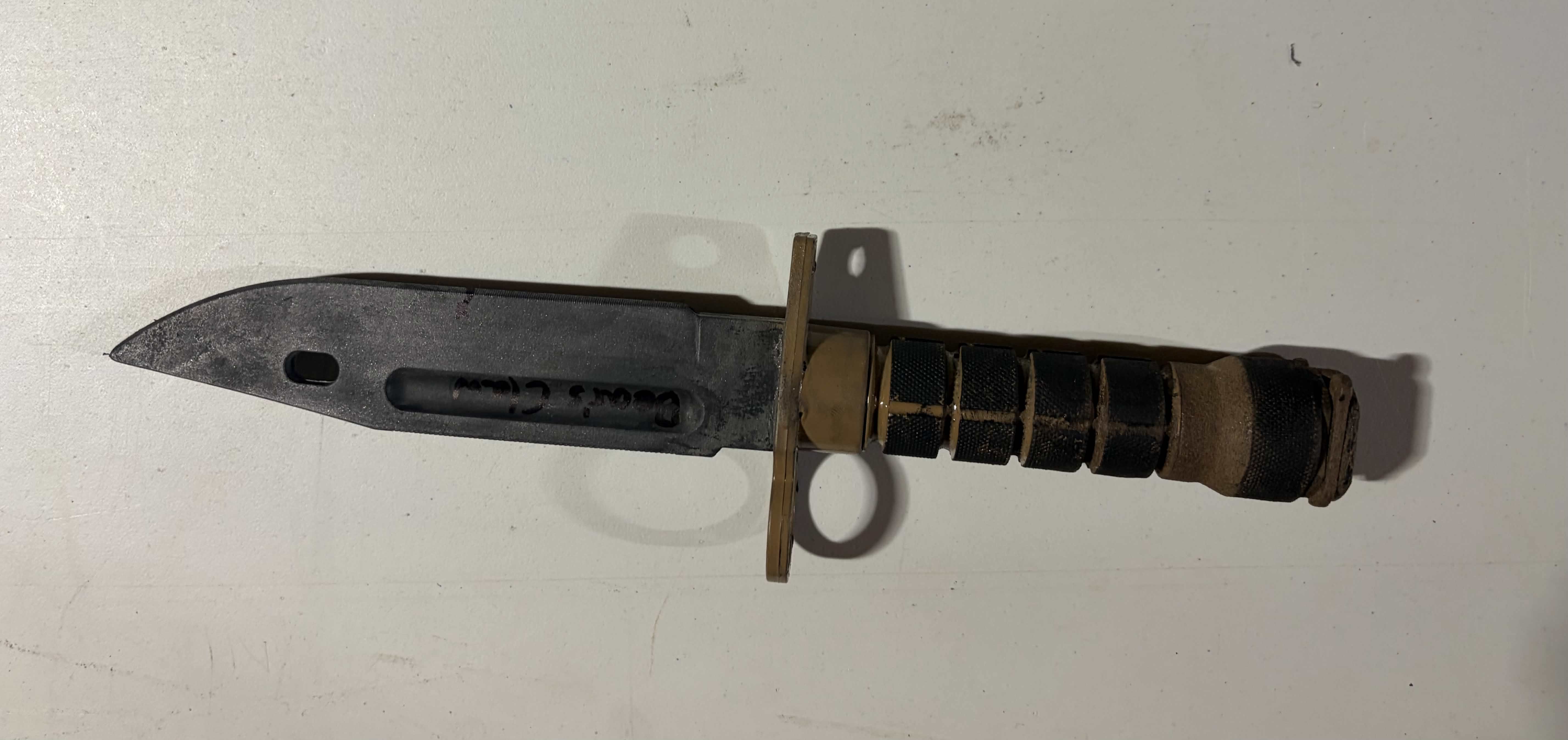 Painted melee bounty knife on a workbench