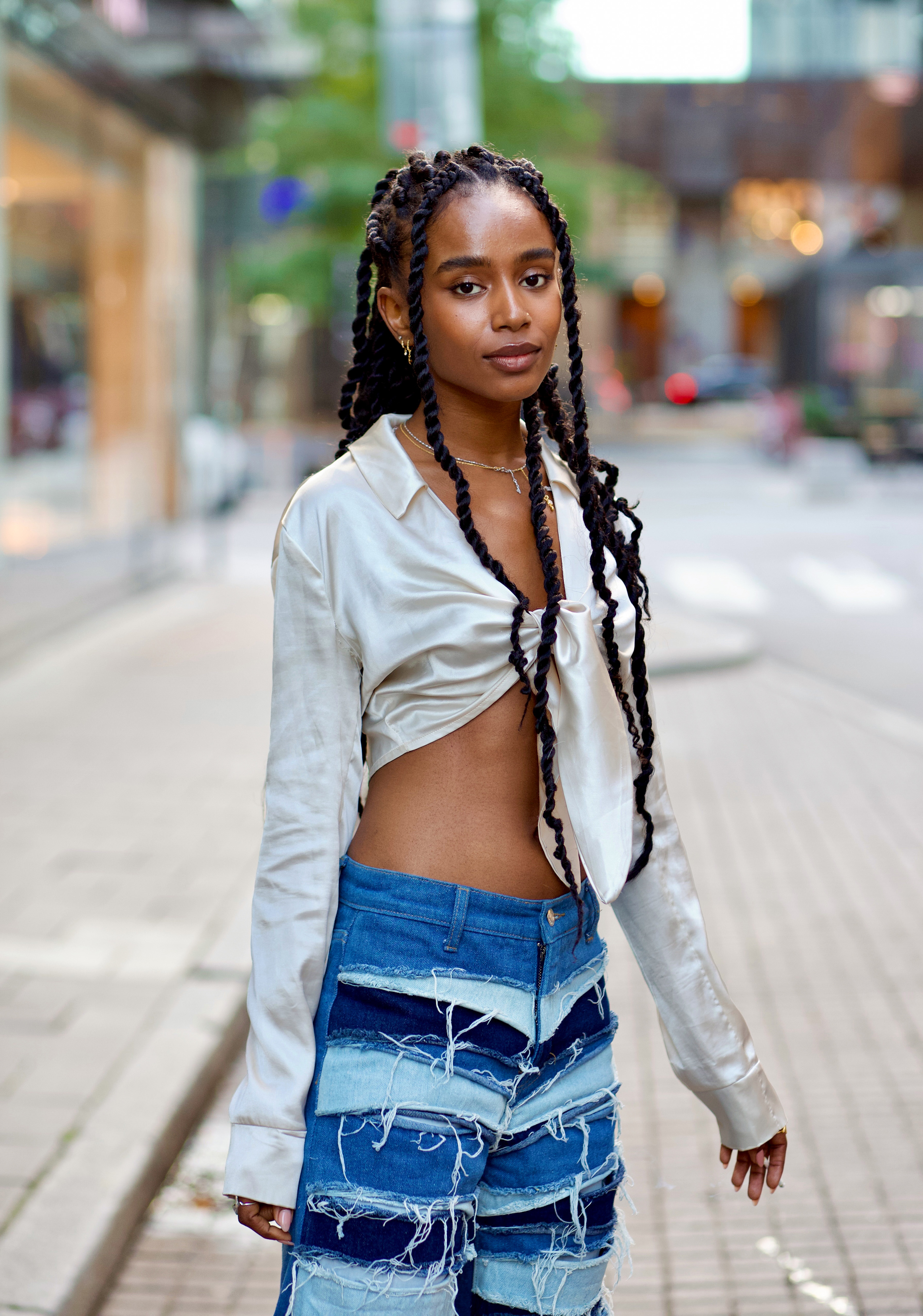 Stockholm fashion week street style photo: a girl wears a silky top with a pair a denim jean