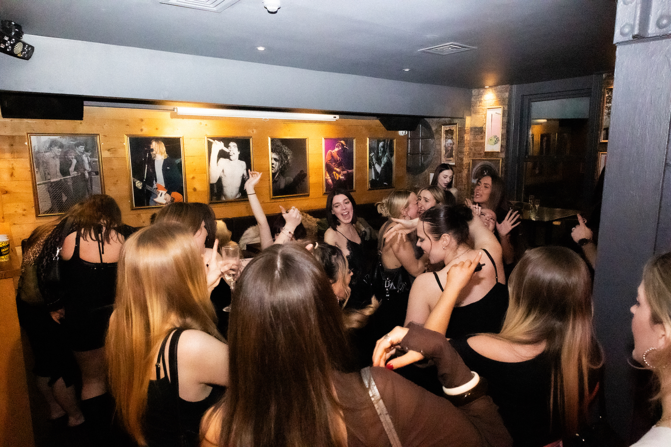 A crowd dancing energetically in a pub.