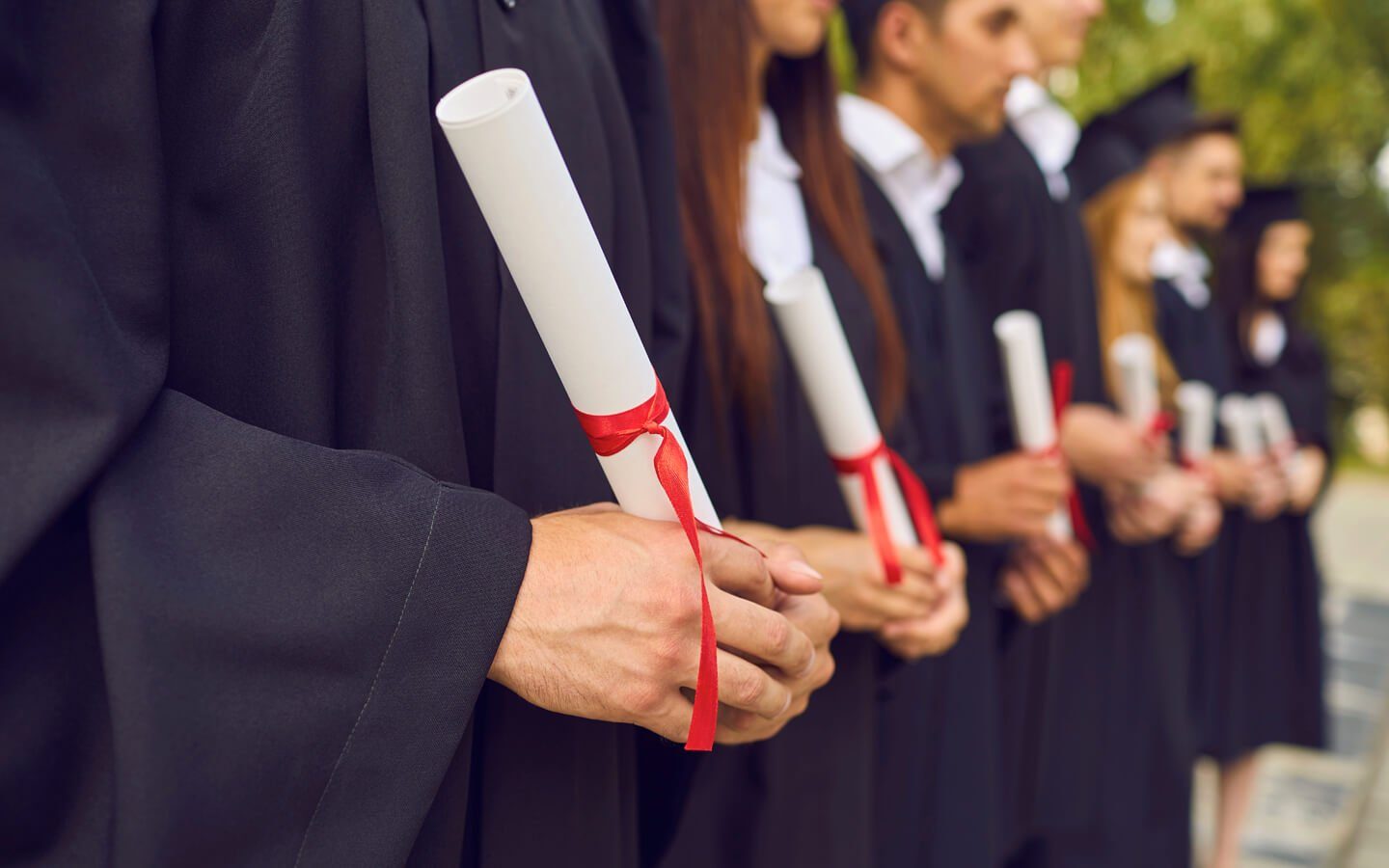 Diploma enrollado con cinta junto a un birrete