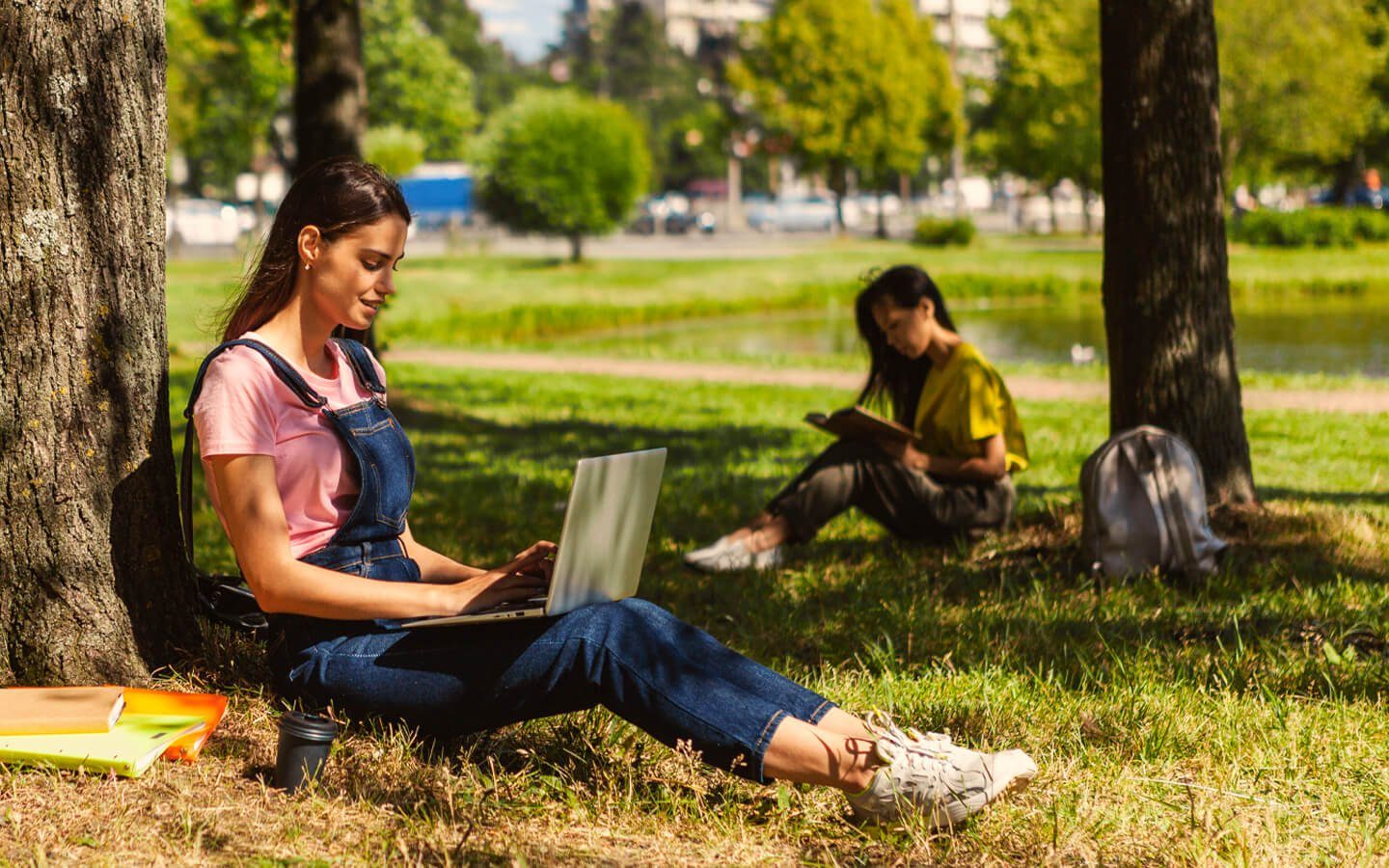 Estudiantes trabajando con portátil al aire libre
