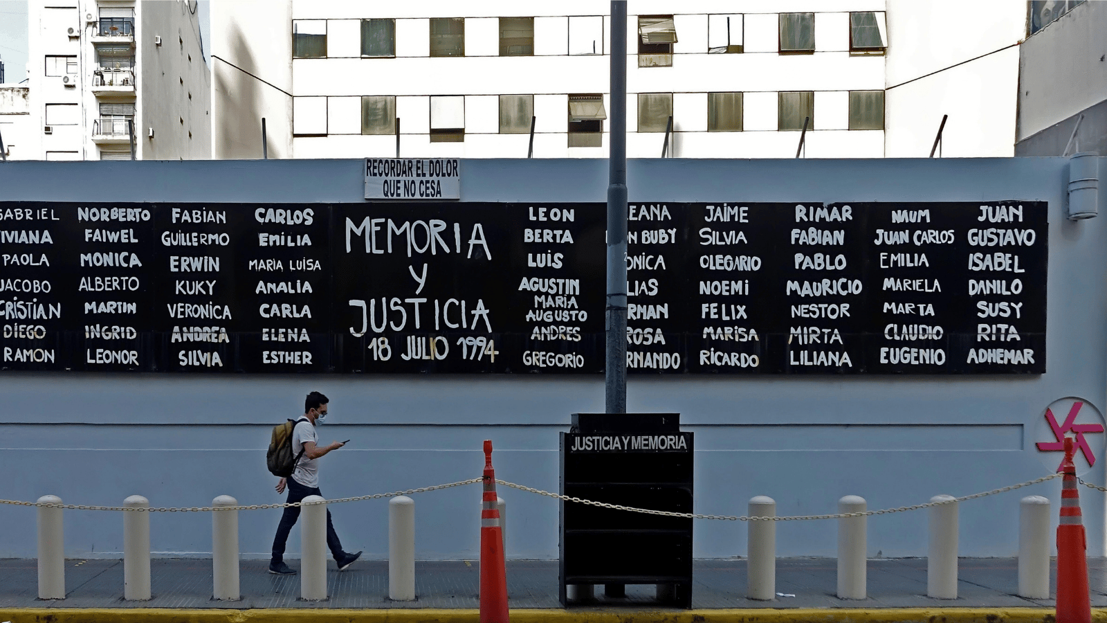 A man walks past a board listing the names of the 85 people killed in the 1994 terrorist attack on the AMIA Jewish Centre in Buenos Aires.