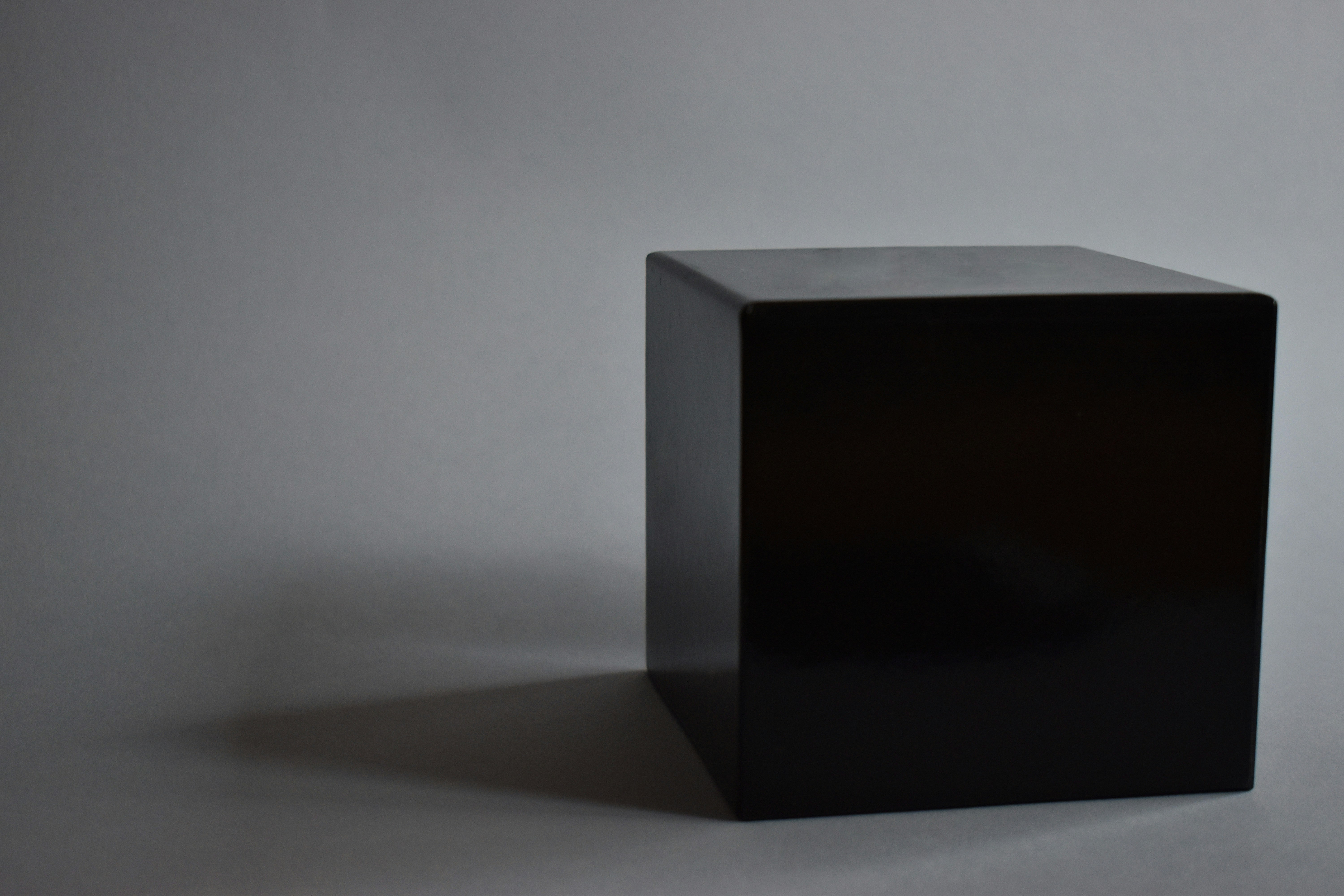 A black box in a gray background projecting a shadow