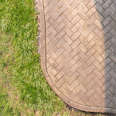 Close-up of herringbone stamped concrete patio edge with curved border detail, Grand Rapids MI