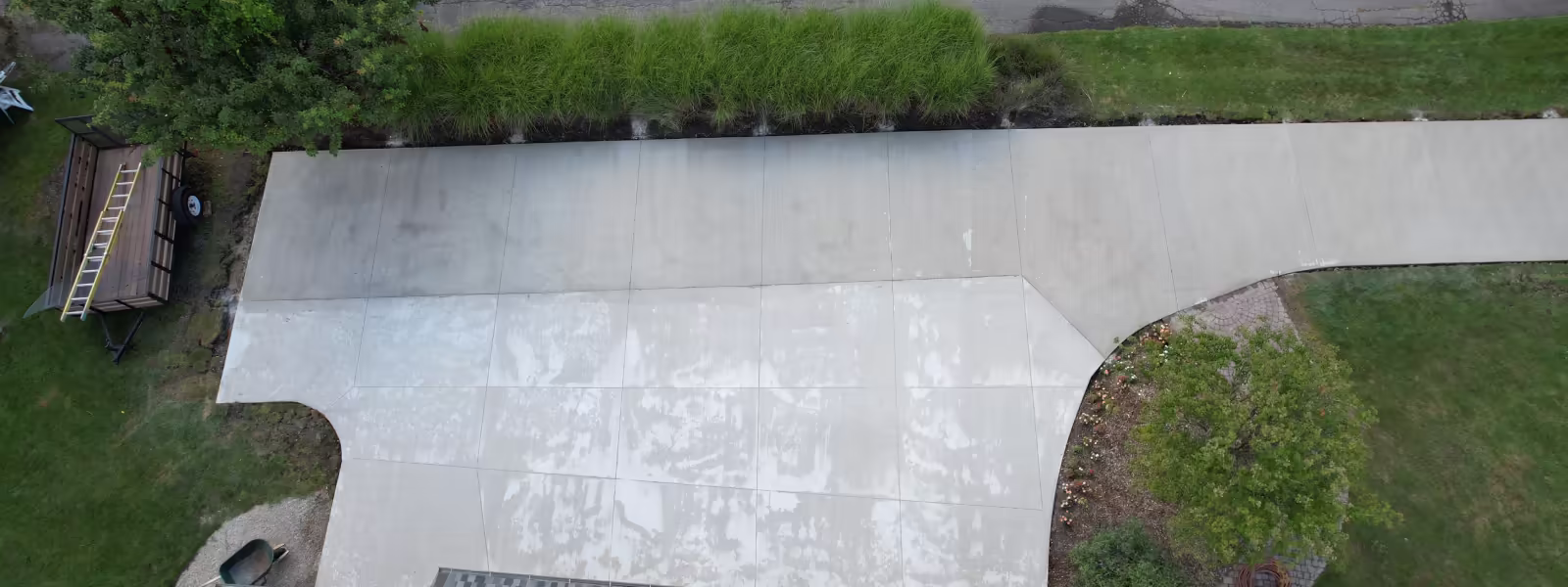 Aerial drone view of large concrete driveway apron with scored expansion joints, rural property Grand Rapids MI