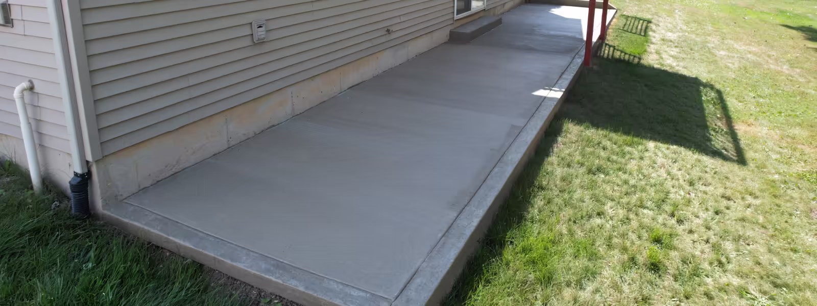 Freshly poured concrete patio and walkway with smooth broom finish, residential home Grand Rapids MI