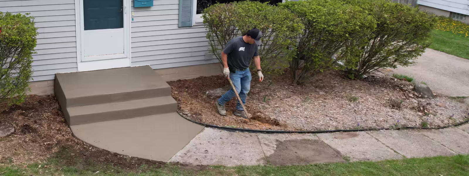 Pro Concrete Services crew finishing new concrete front steps and curved walkway apron, Grand Rapids MI