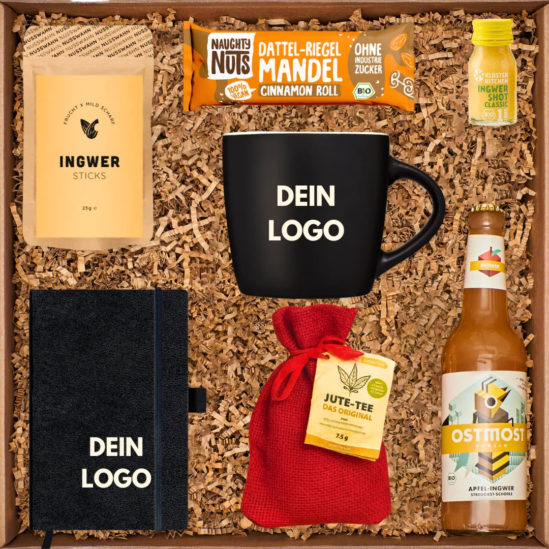 Onboarding Geschenkbox von GIVEAJOY aus Berlin mit gebrandeter Tasse, Notizbuch, Tee, Ingwer-Sticks, Bio-Drink und veganem Snackriegel – nachhaltiges Mitarbeitergeschenk mit individuellem Firmenlogo.
