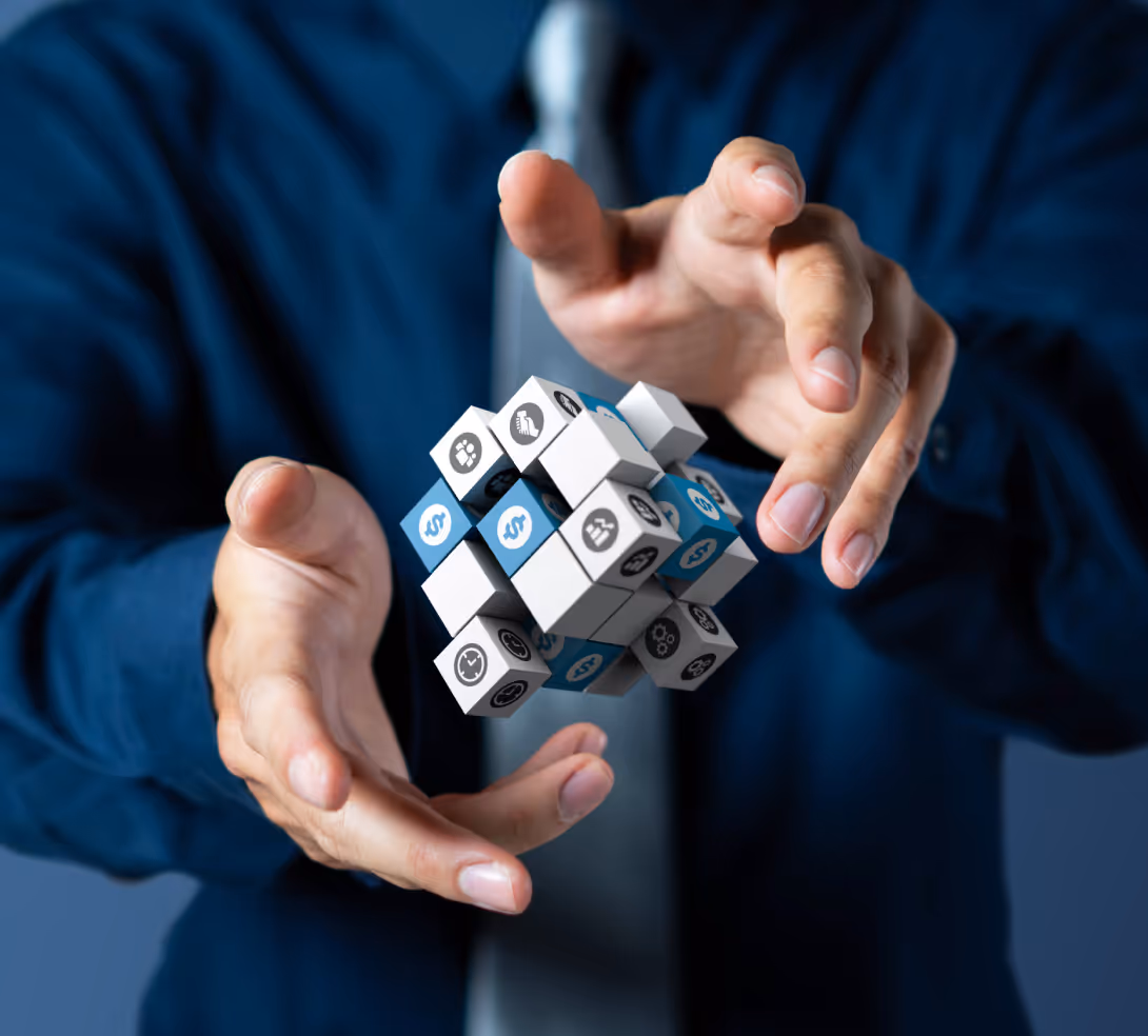 Businessman holding a cube against a blue background, symbolizing innovation and strategy in a corporate setting.