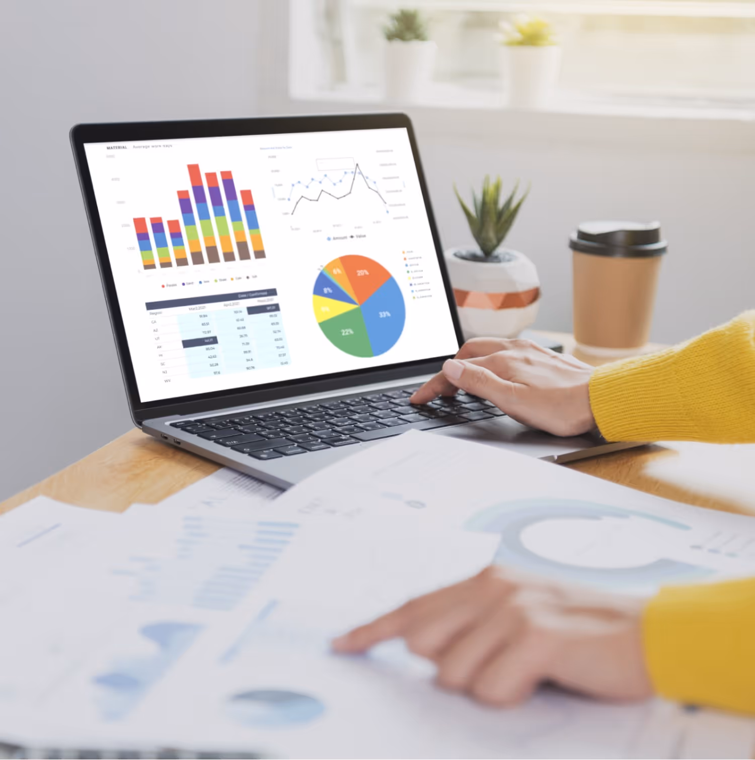 Businesswoman working on a laptop, analyzing graphs and charts displayed on the screen.