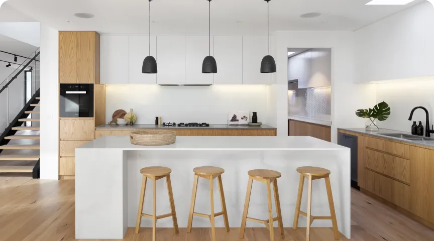 Open-concept kitchen with white island and wood cabinetry after a split-level home remodel.