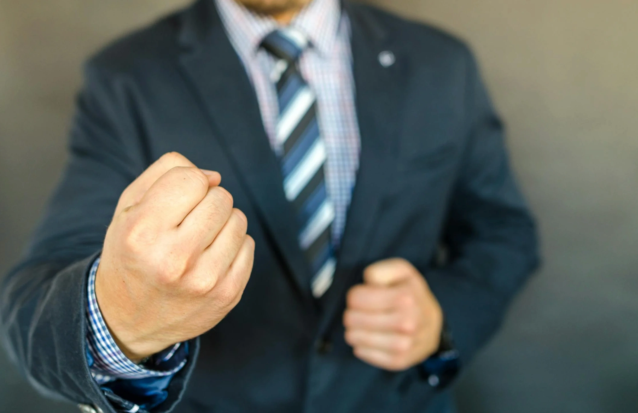 man in suit clenching fist