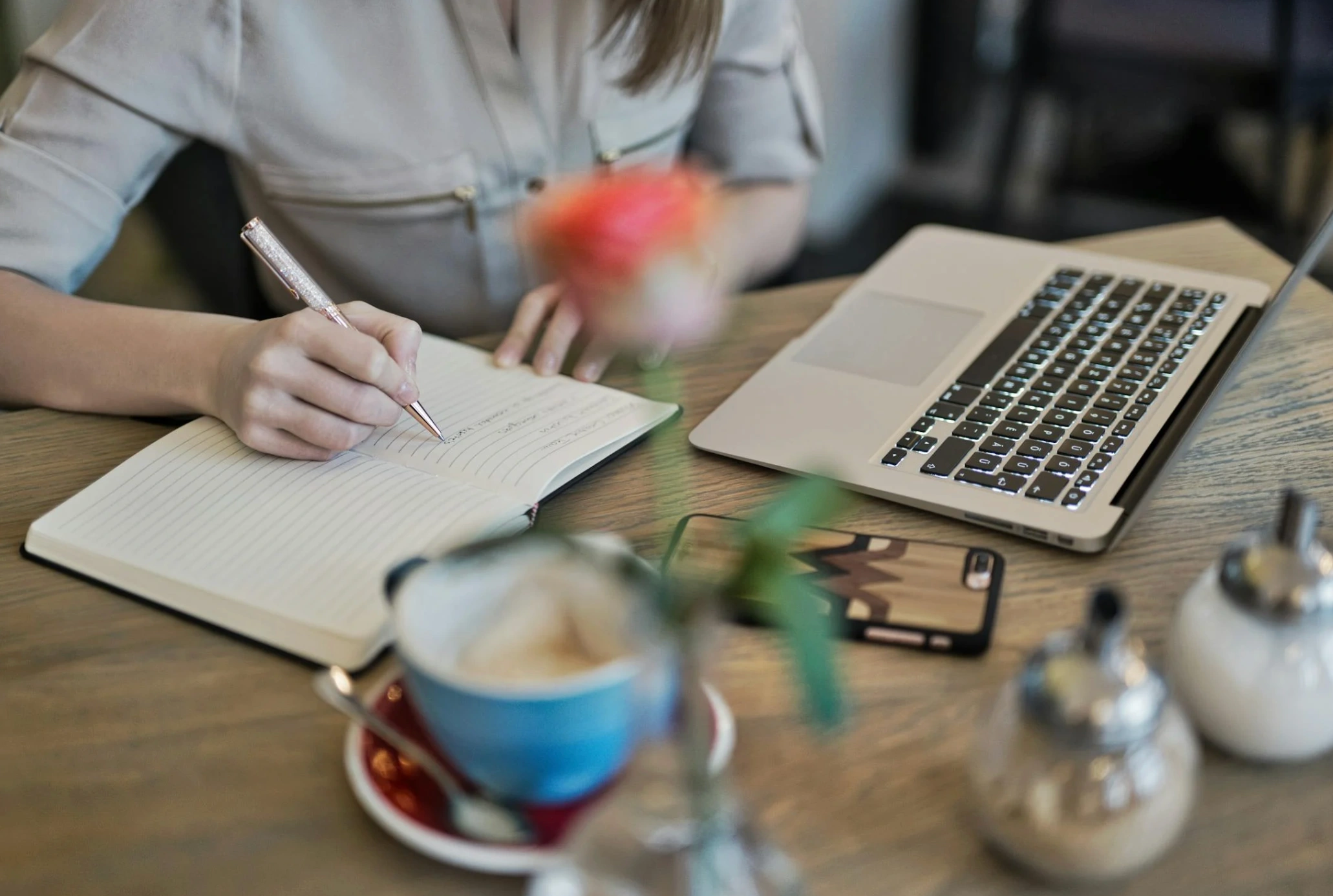 person taking notes by laptop